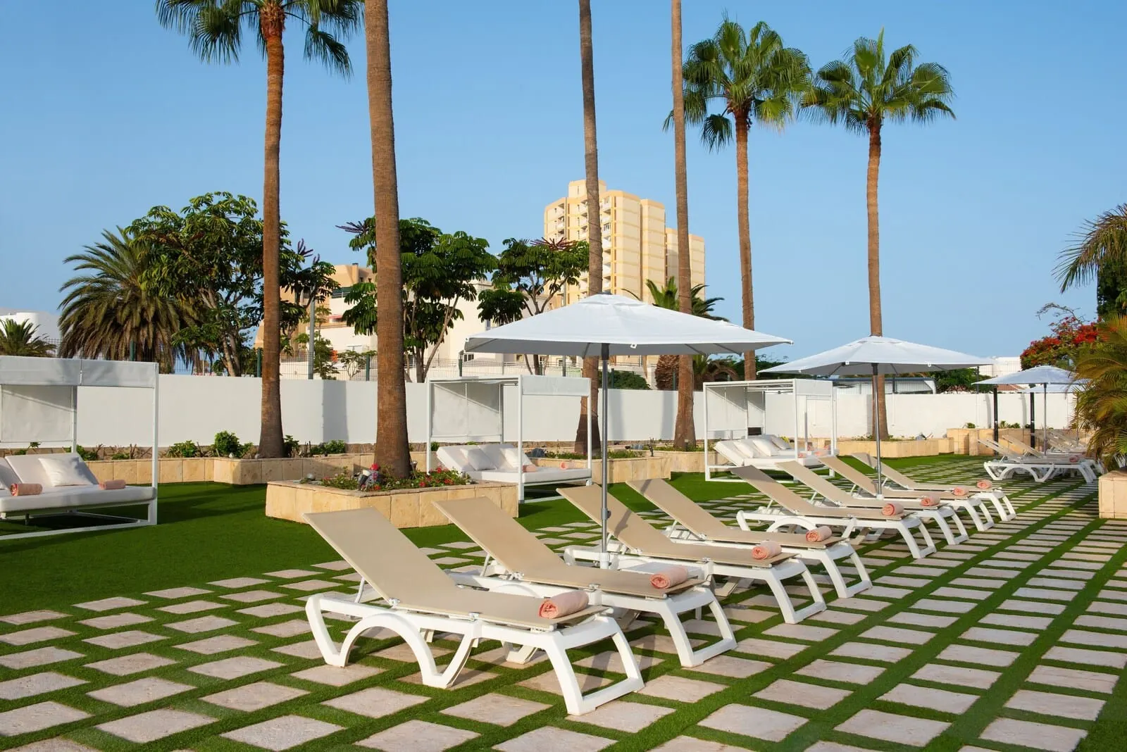 Olé Tropical Tenerife: A poolside area with sun loungers and umbrellas