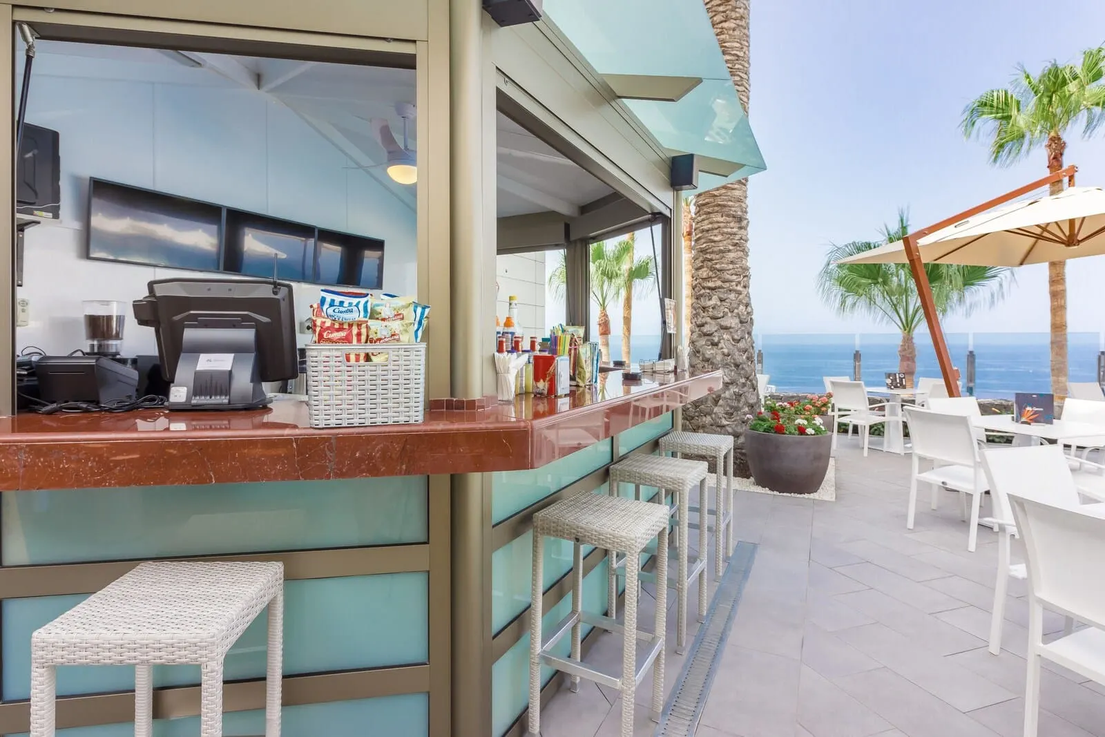Klayman Diamond Aparthotel: A bar area with a counter, bar stools, and outdoor seating with umbrellas