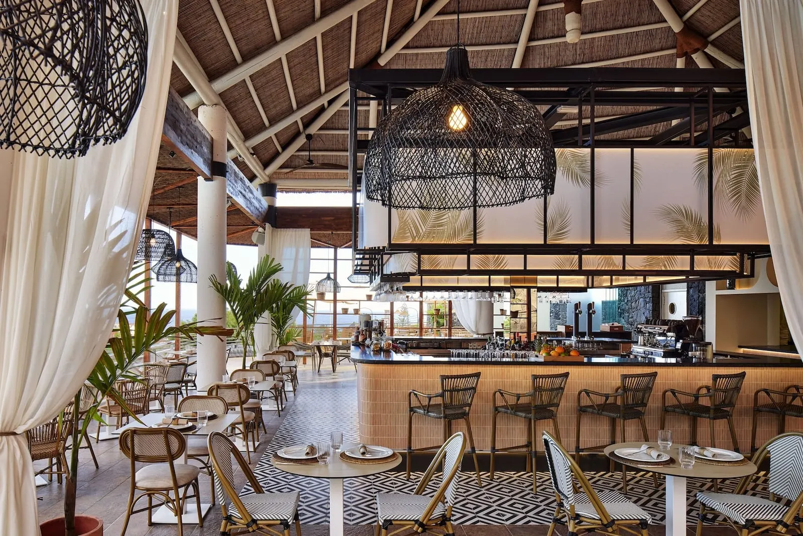 Meliá Jardines del Teide: A restaurant with a bar area, wicker chairs, and a patterned floor