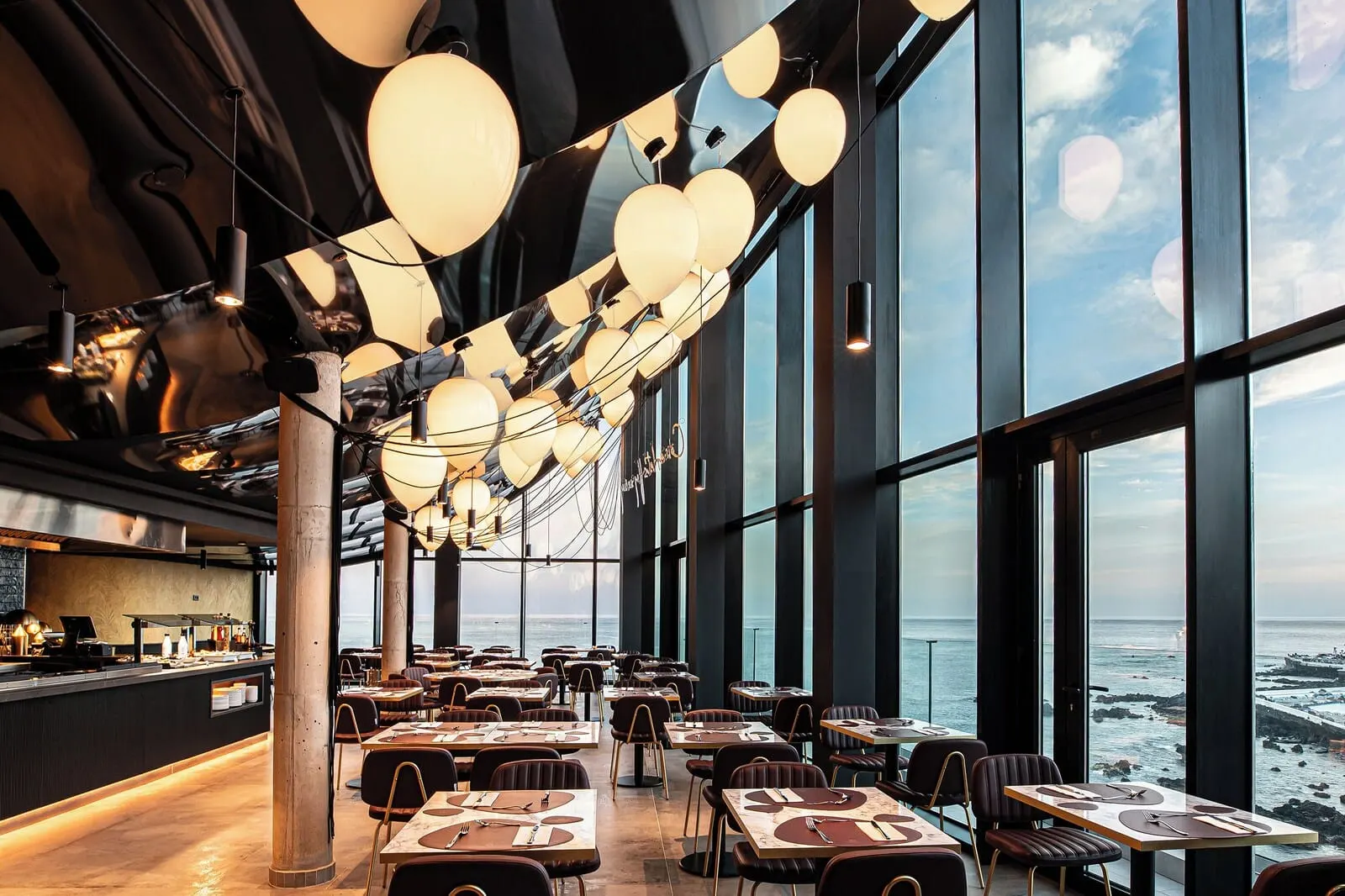 Silken Saaj Maar: A restaurant with a long table layout, large windows