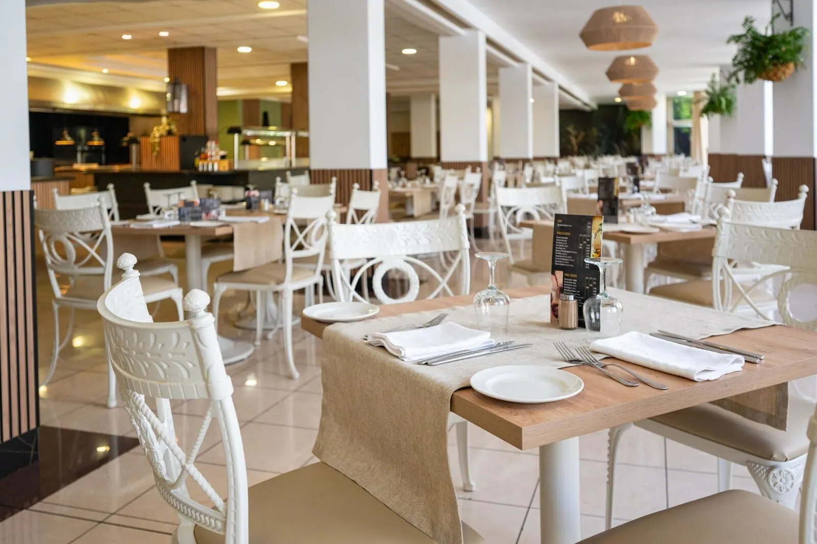 Hotel Puerto Palace: A restaurant with white chairs and tables, a menu stand