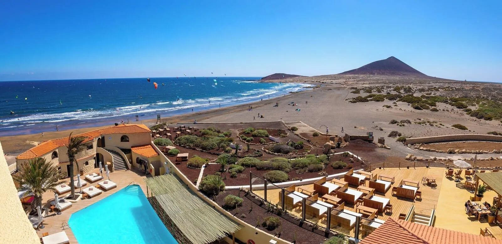 Playa Surf CBbC Hotel: A resort with a pool, outdoor seating, and a view of the beach and a mountain