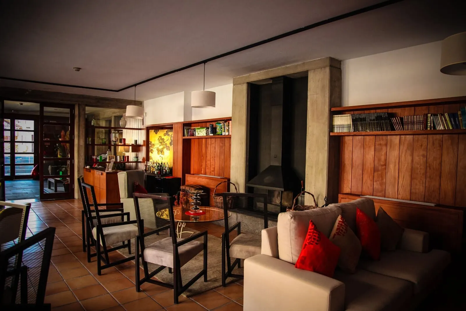 Hotel La Casona del Patio: A modern living room with a fireplace, wooden bookshelves