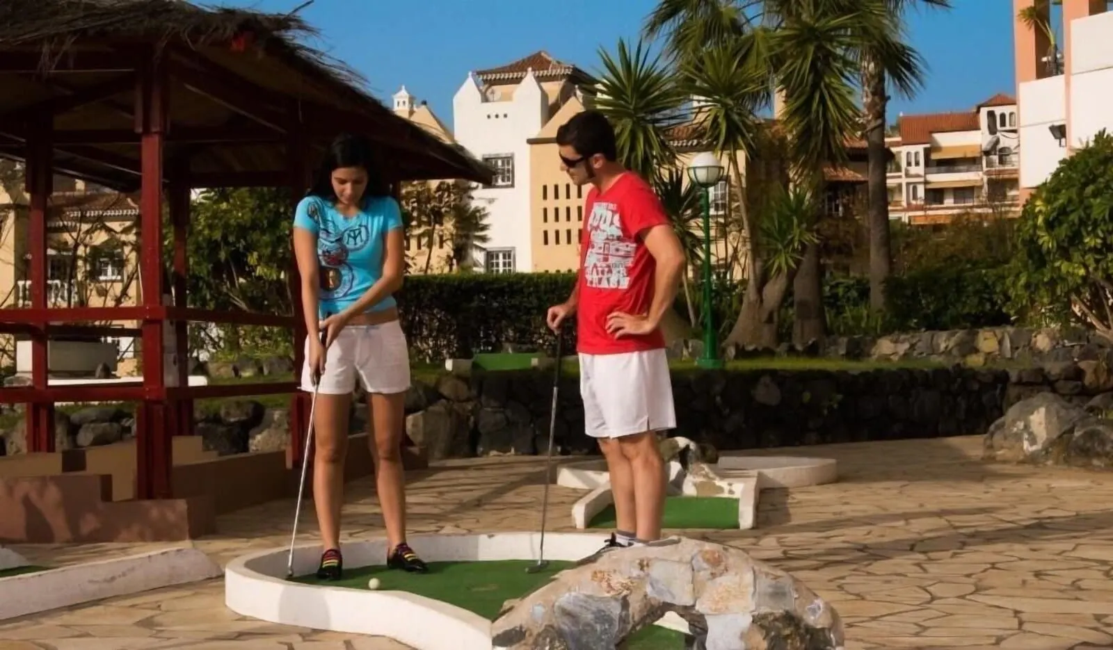 Hotel Puerto Palace: A miniature golf course with a gazebo, palm trees, and a stone pathway