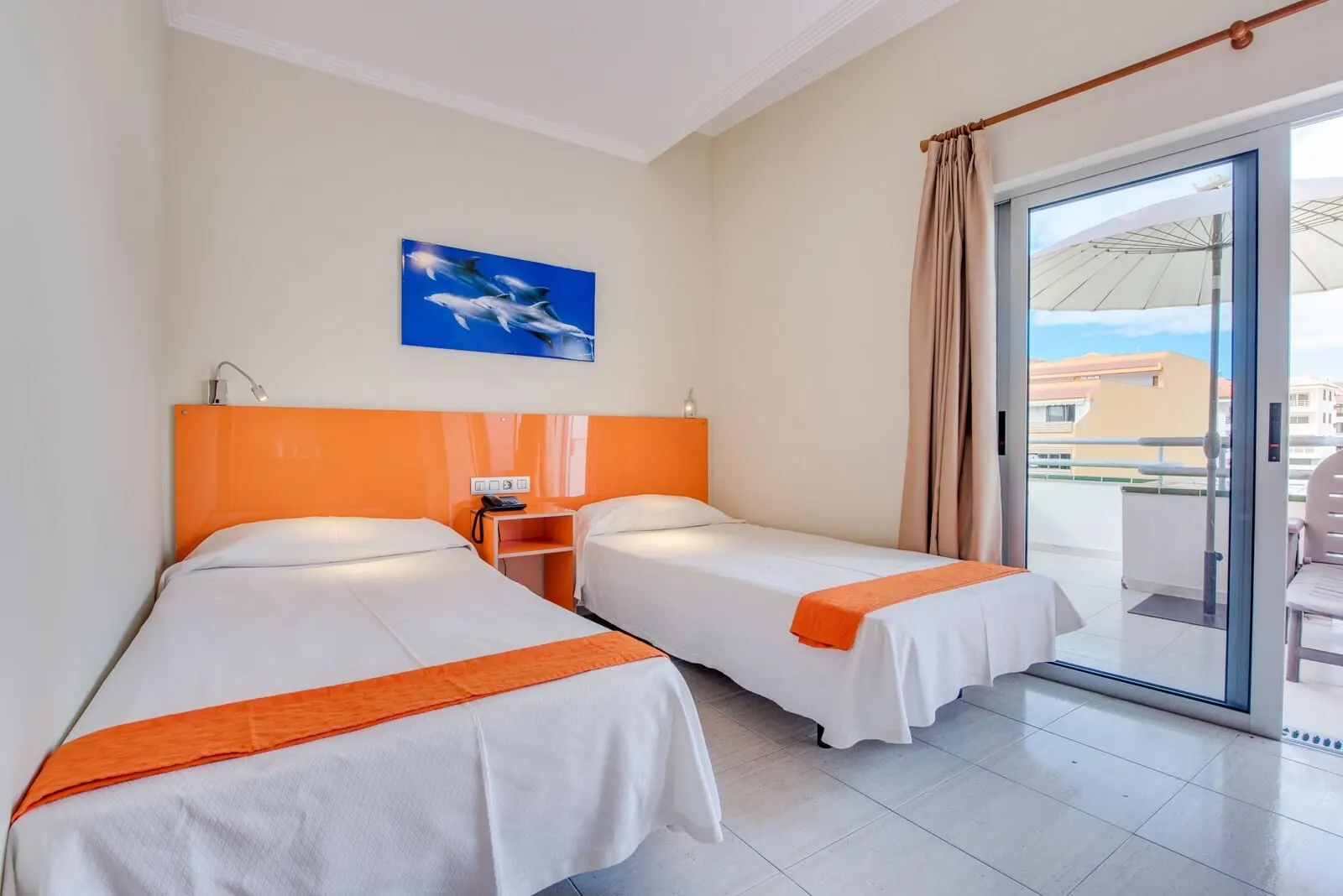 Andrea's Hotel Tenerife: A hotel room with two beds, a painting of dolphins, a balcony with a view