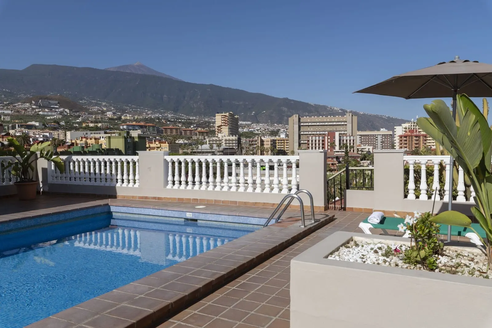 Hotel Marte: A rooftop pool with a view of a cityscape and mountains in the distance