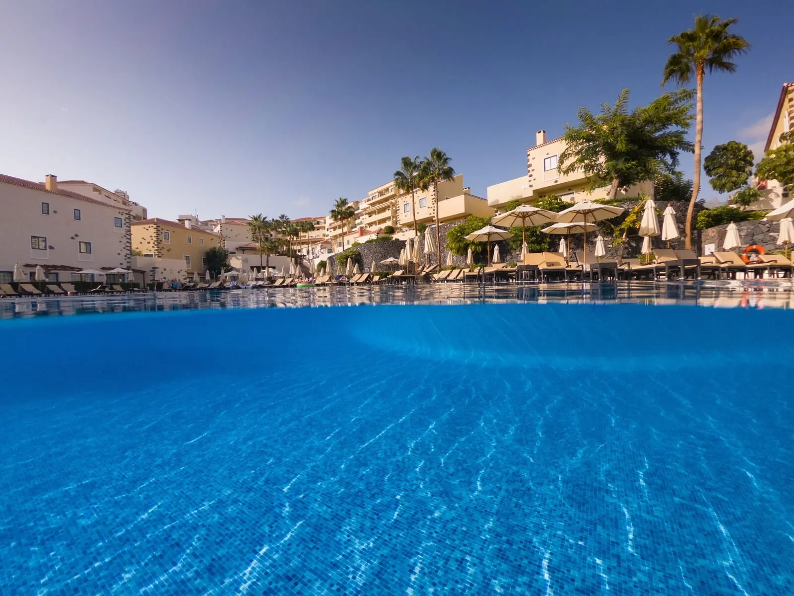GF Isabel: A clear blue pool with lounge chairs and umbrellas