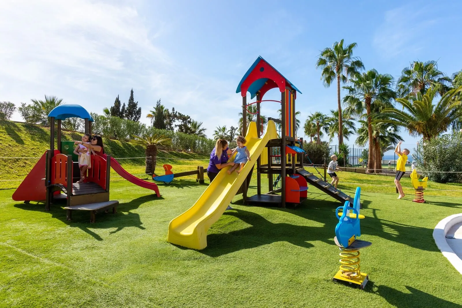 Hotel Tropical Park: A playground with various play structures including slides and climbing areas