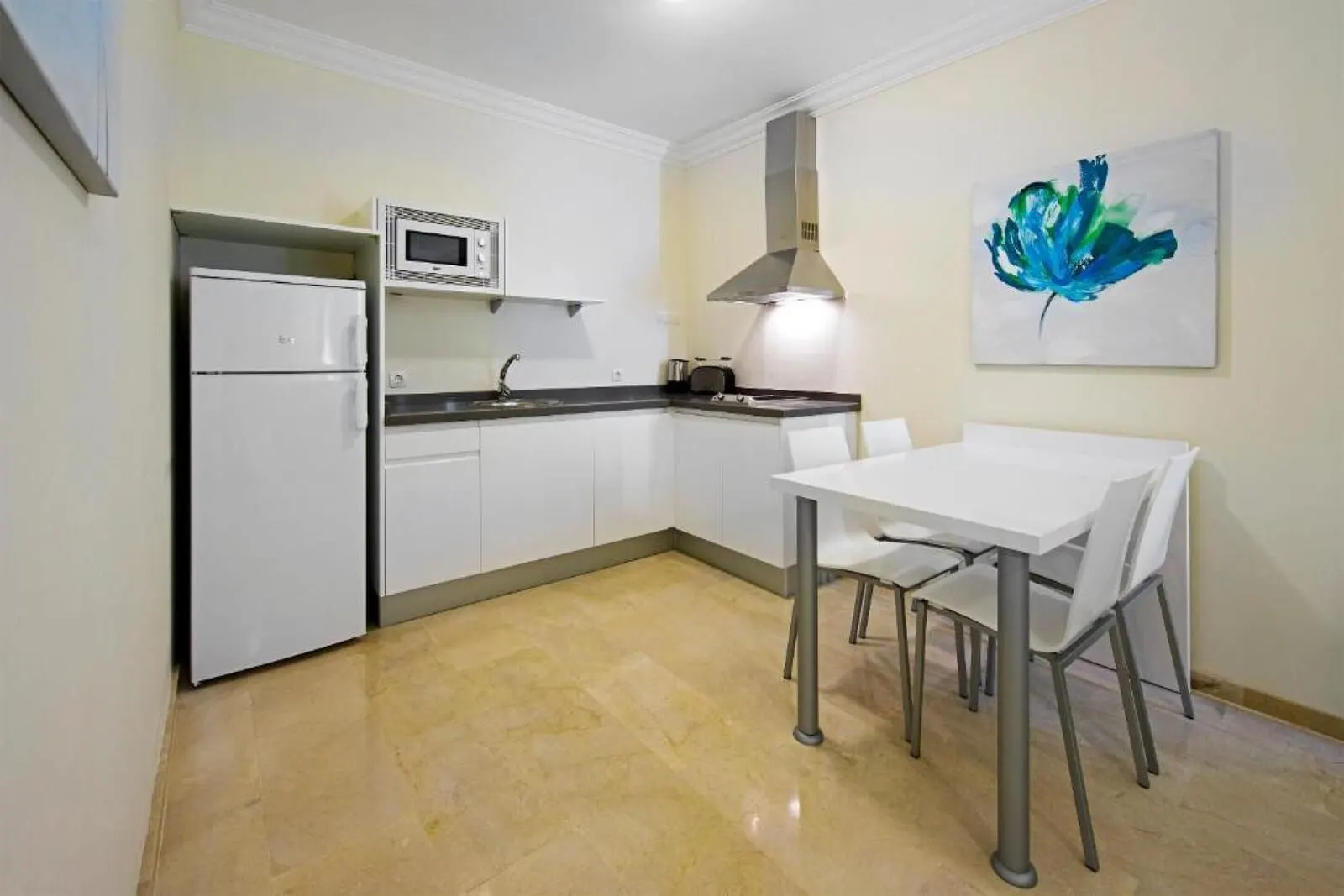KN Aparthotel Panorámica: A compact kitchen with white cabinets, a microwave, a stove