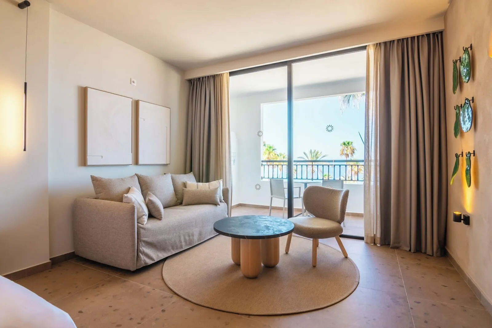 Bahia Principe Escape Tenerife: A modern hotel room with a sofa, armchair, and round coffee table