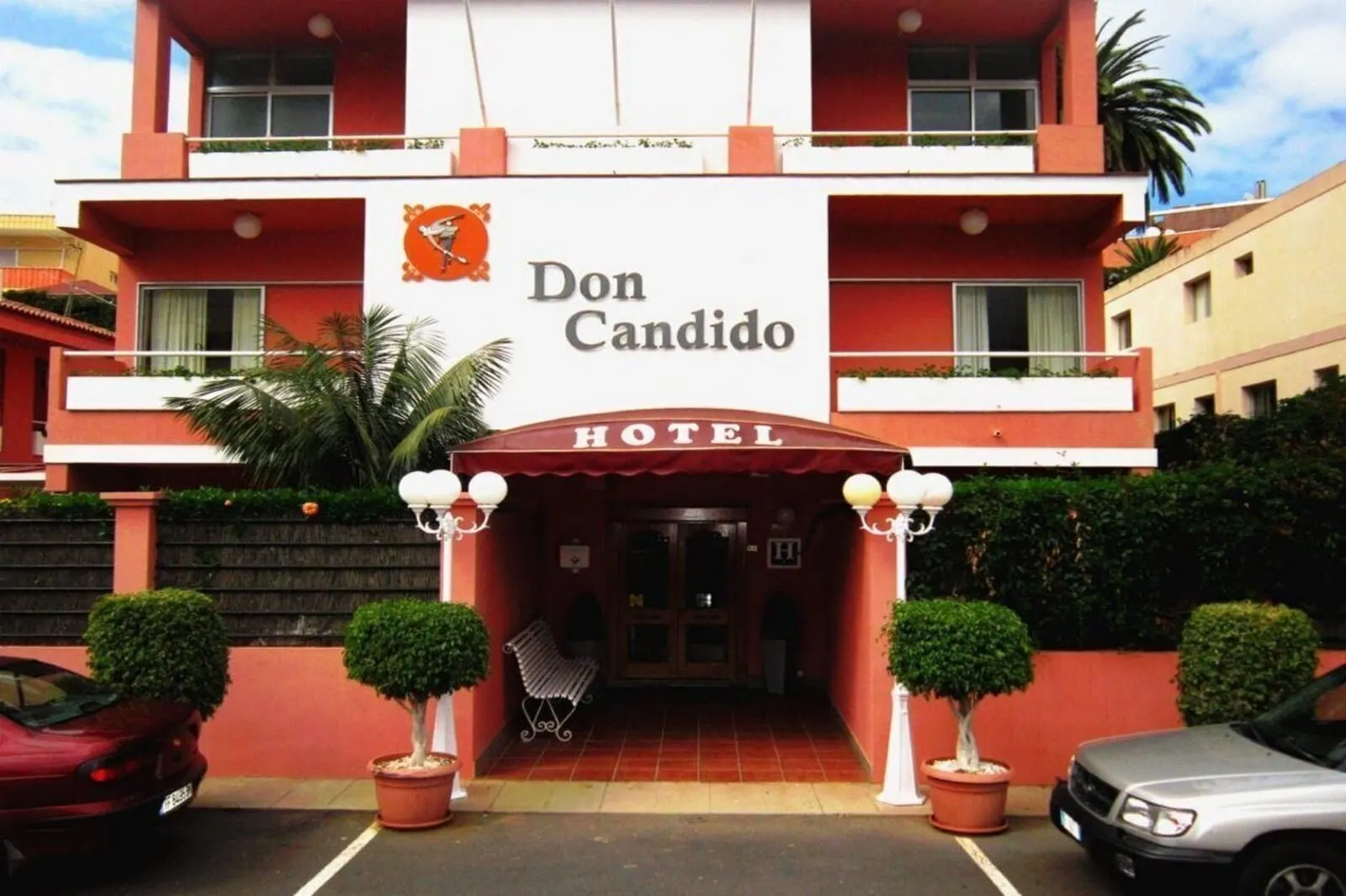 Hotel Don Cándido: A hotel named Don Candido with a red and white facade, a central entrance
