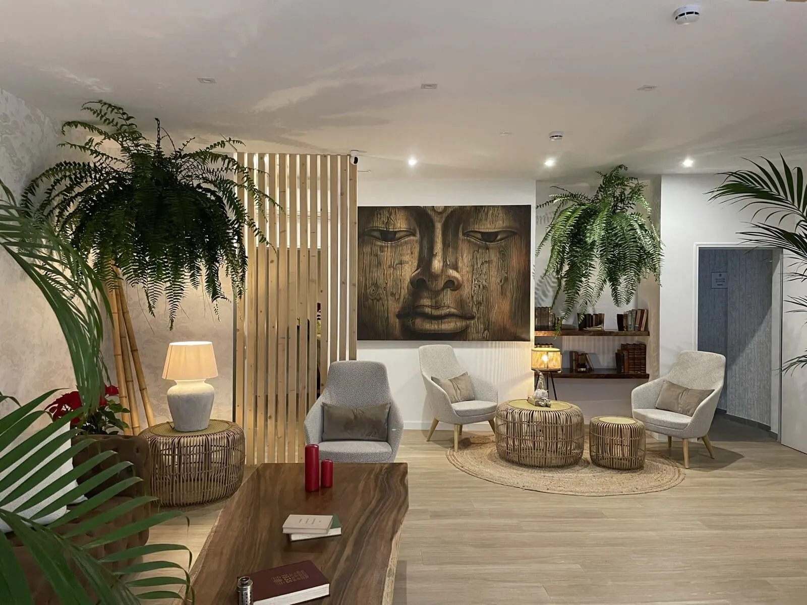 Hi Suites: A modern living room with a wooden coffee table, two grey armchairs
