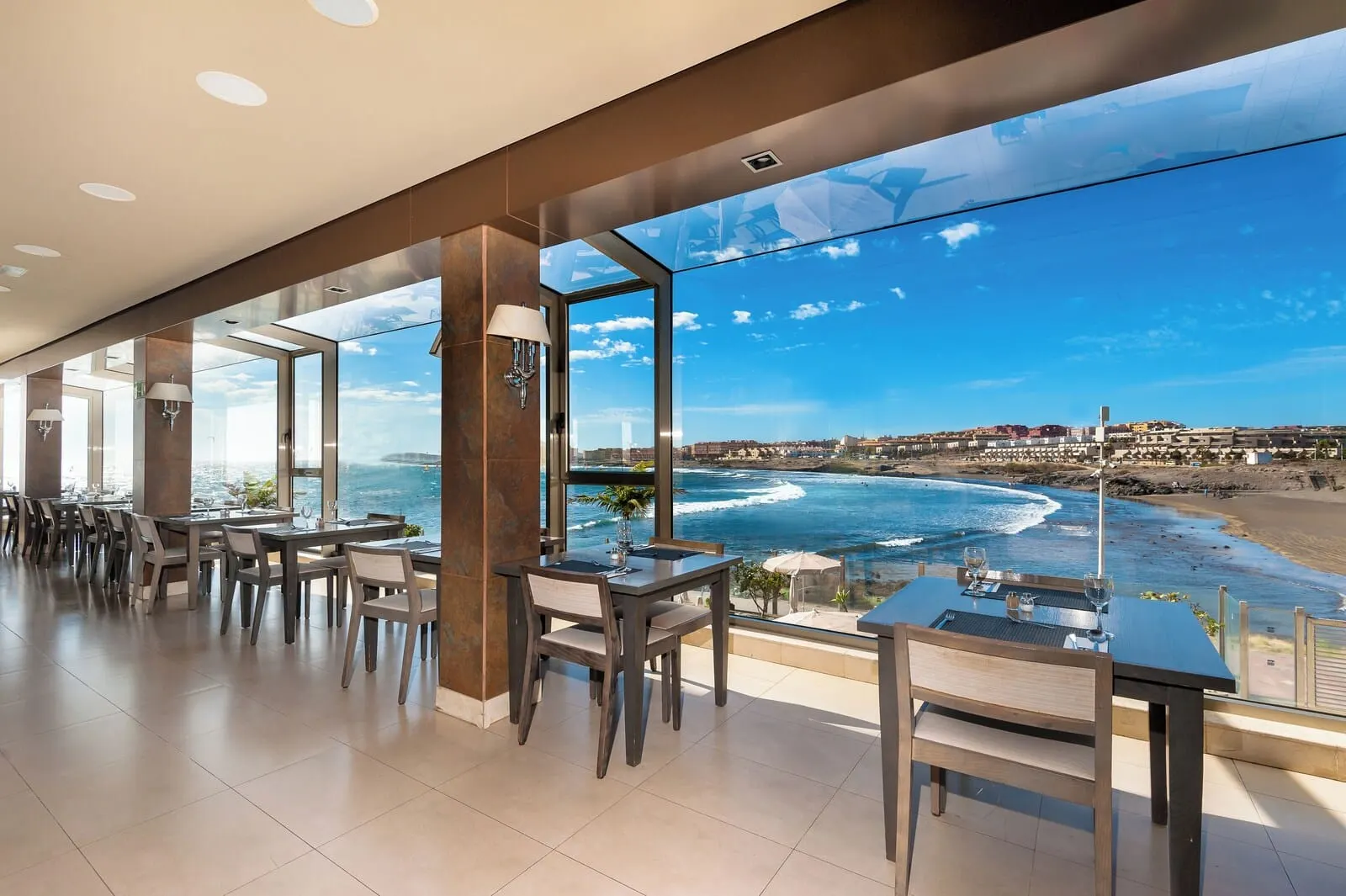 KN Hotel Arenas del Mar: A modern dining area with large windows overlooking a beach and ocean view