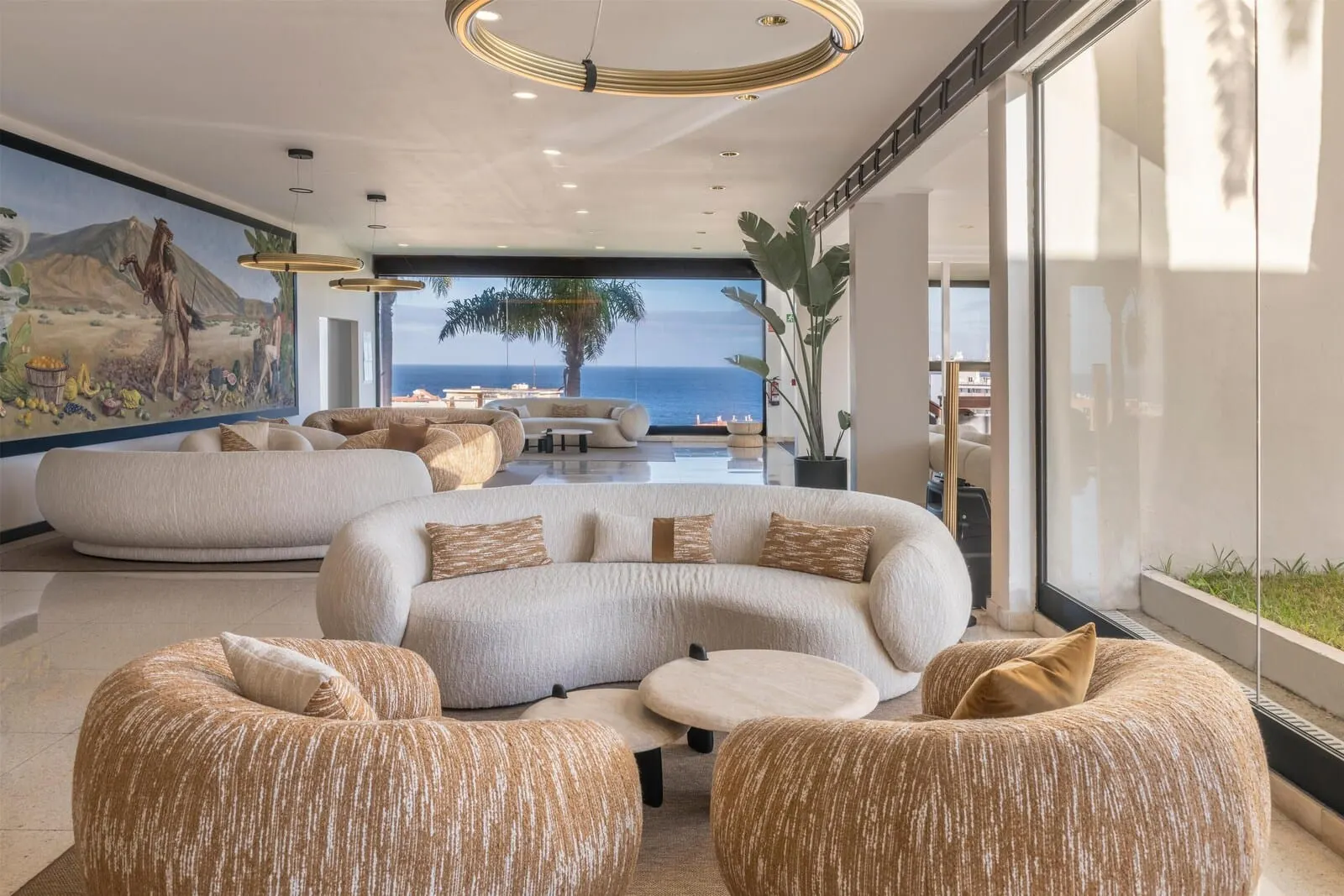 Hotel Atlantic El Tope: A modern living room with a large sectional sofa, round ottomans