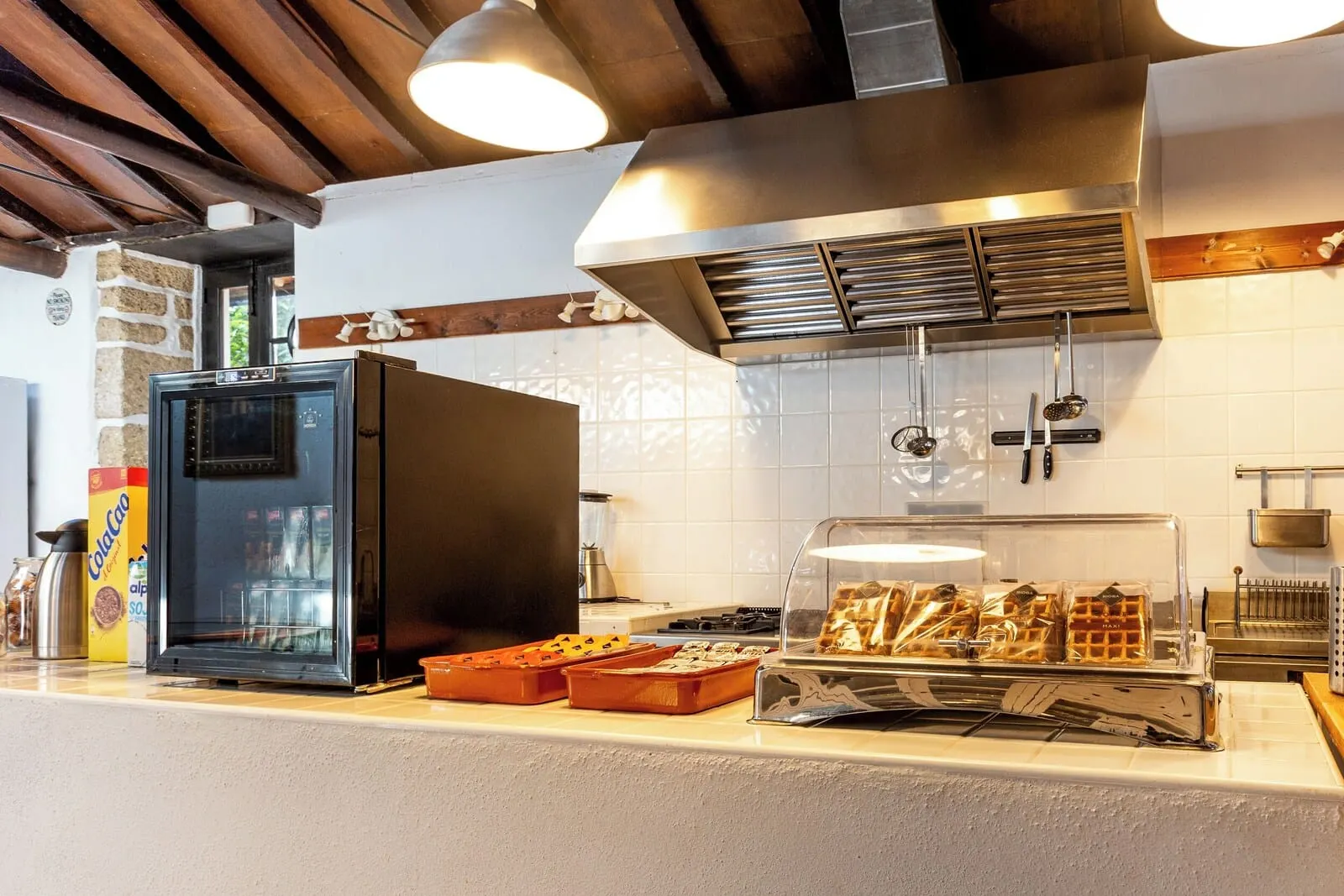 Hotel Duque de la Torre: A kitchen with a refrigerator, a waffle maker, and a coffee machine