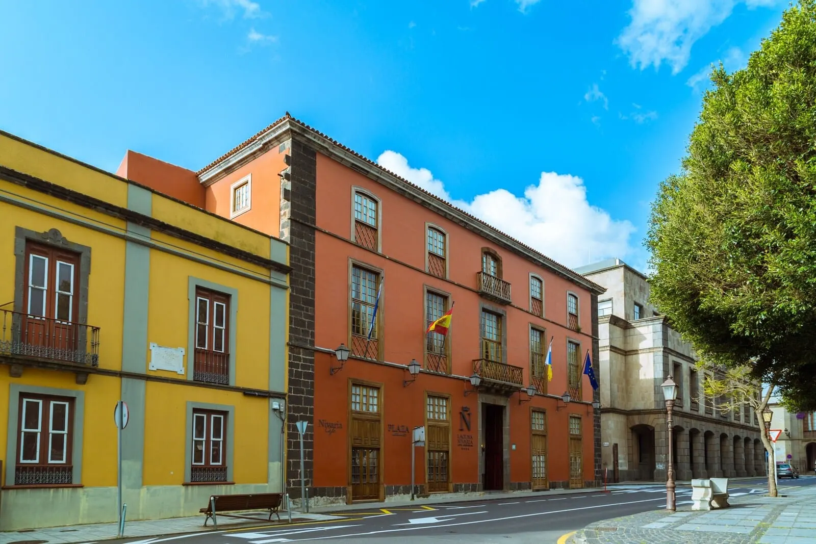 Laguna Nivaria Hotel & Spa: A street view with colorful buildings, a bench, and a clear blue sky