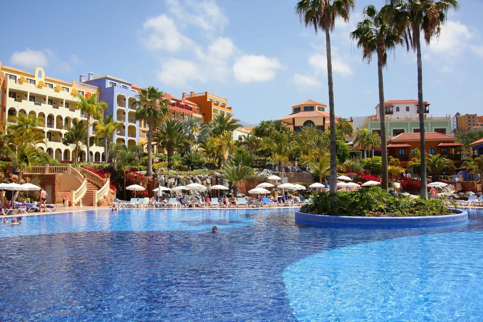 Bahia Principe Explore Costa Adeje: A large swimming pool with lounge chairs and umbrellas