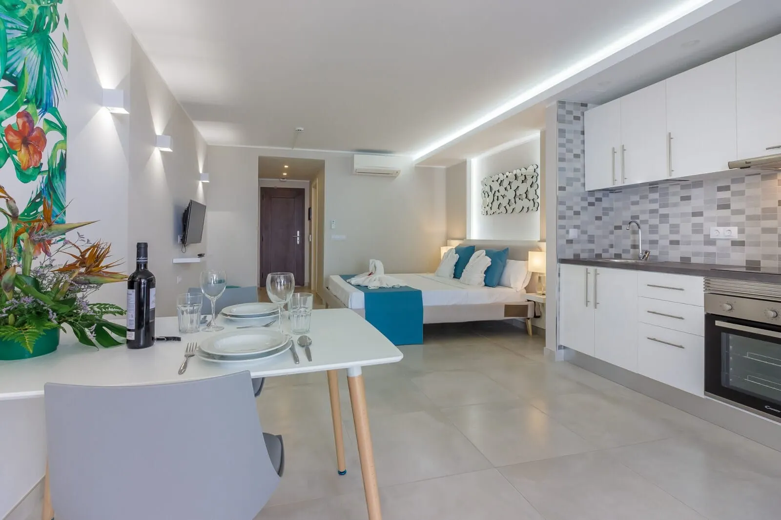 Klayman Diamond Aparthotel: A modern kitchen with white cabinets, a built-in oven, and a tiled backsplash