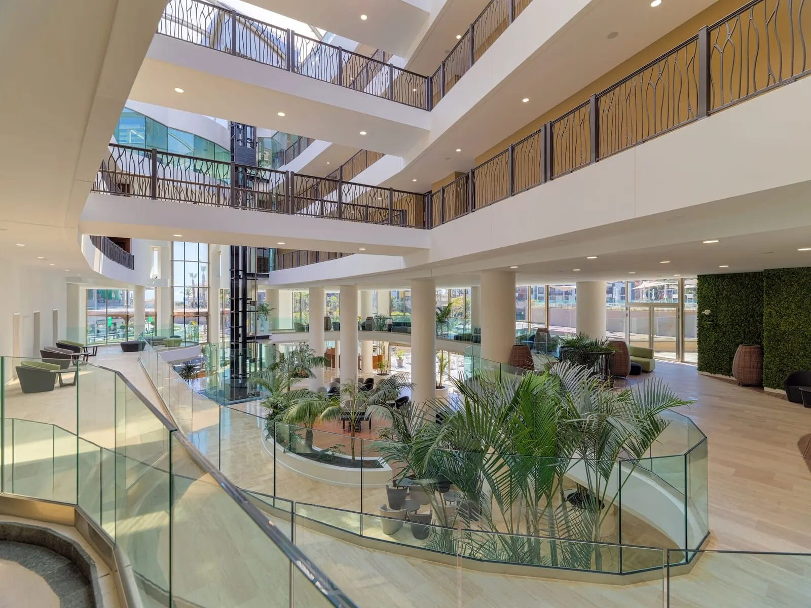 GF Victoria: A multi-level atrium with glass railings, seating areas, and indoor plants