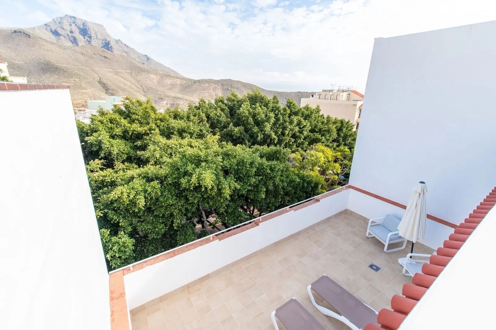 Suncanarias Hotel Adeje Plaza: A rooftop terrace with a view of a mountainous landscape