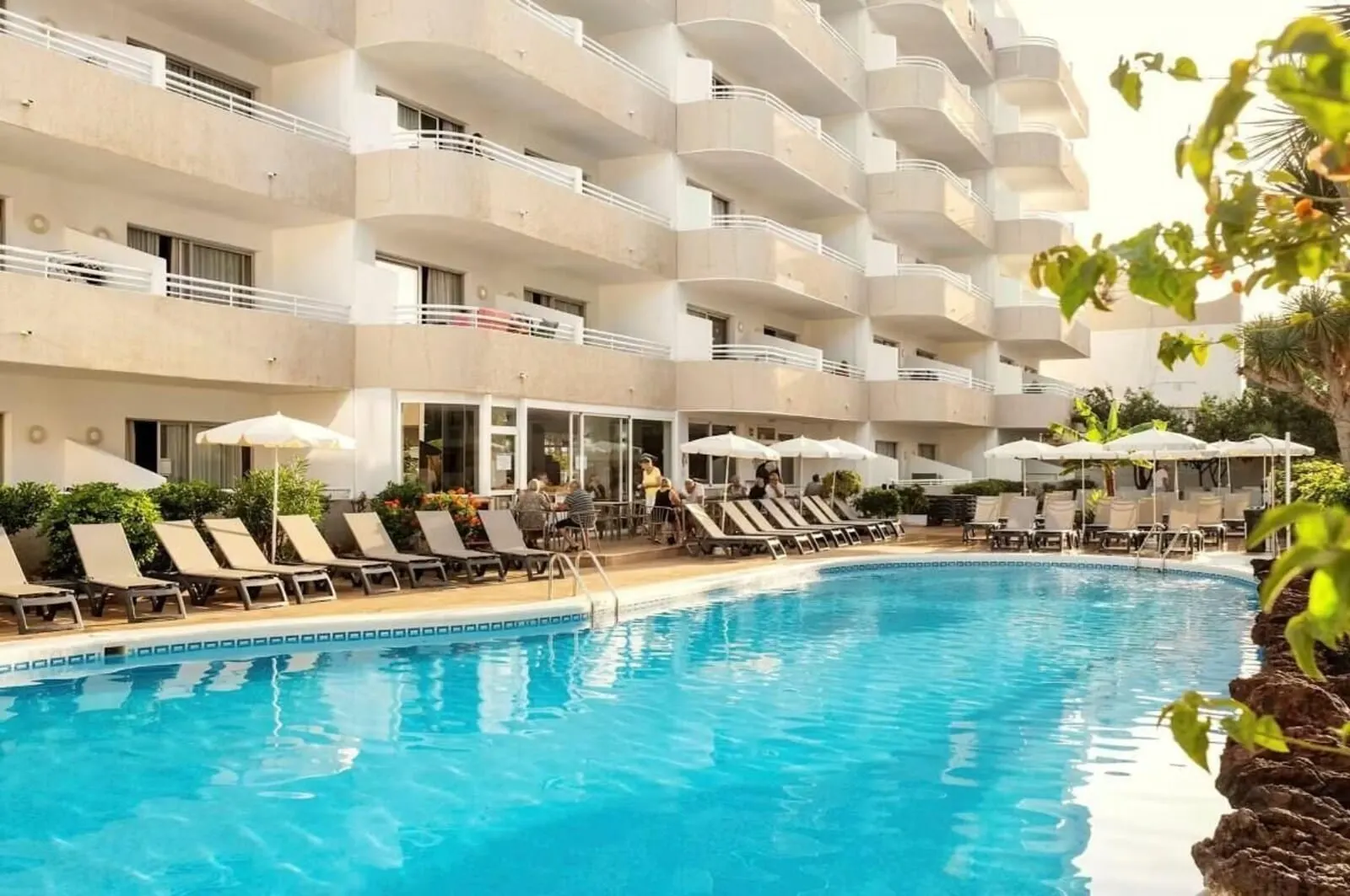 Coral California: A hotel with a swimming pool, sun loungers, and umbrellas