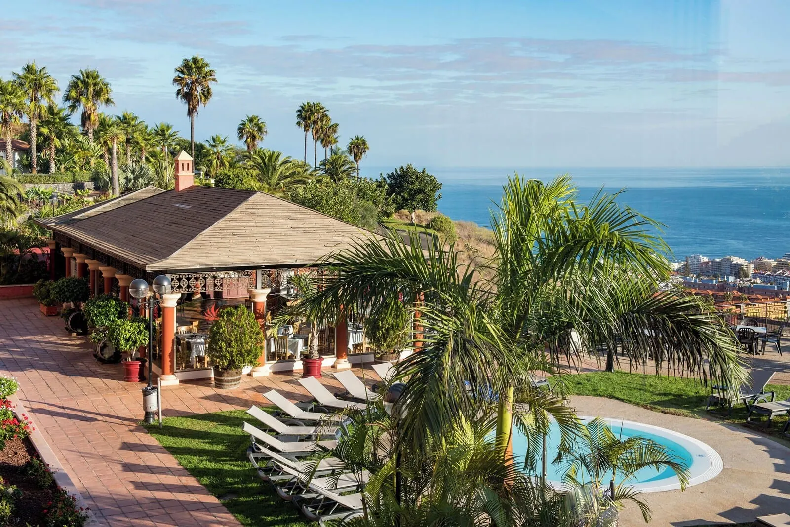 Hotel Las Águilas Tenerife, Affiliated by Meliá: A resort with a pool, palm trees, and a view of the ocean