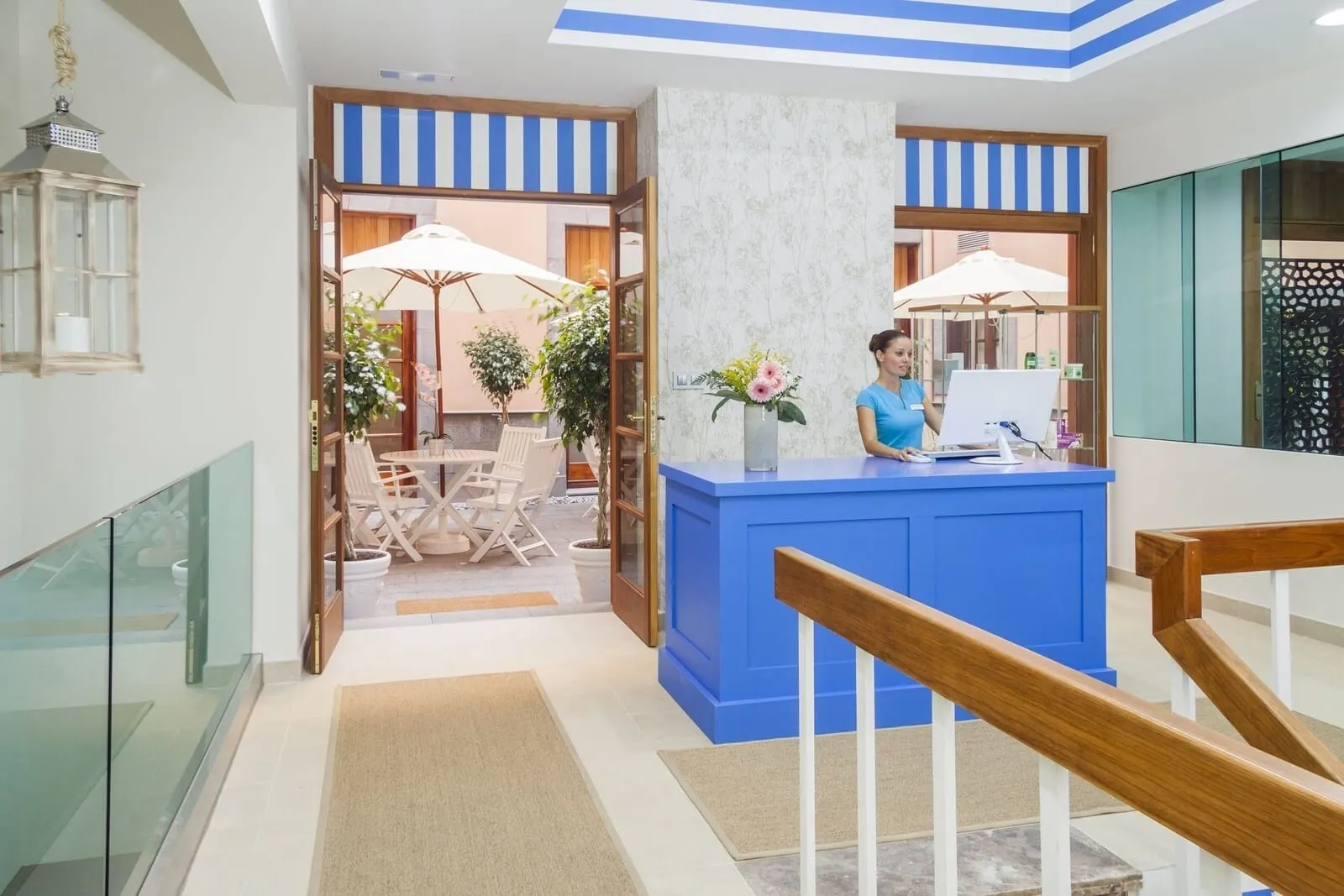 Laguna Nivaria Hotel & Spa: A reception area with a blue counter, a wooden railing