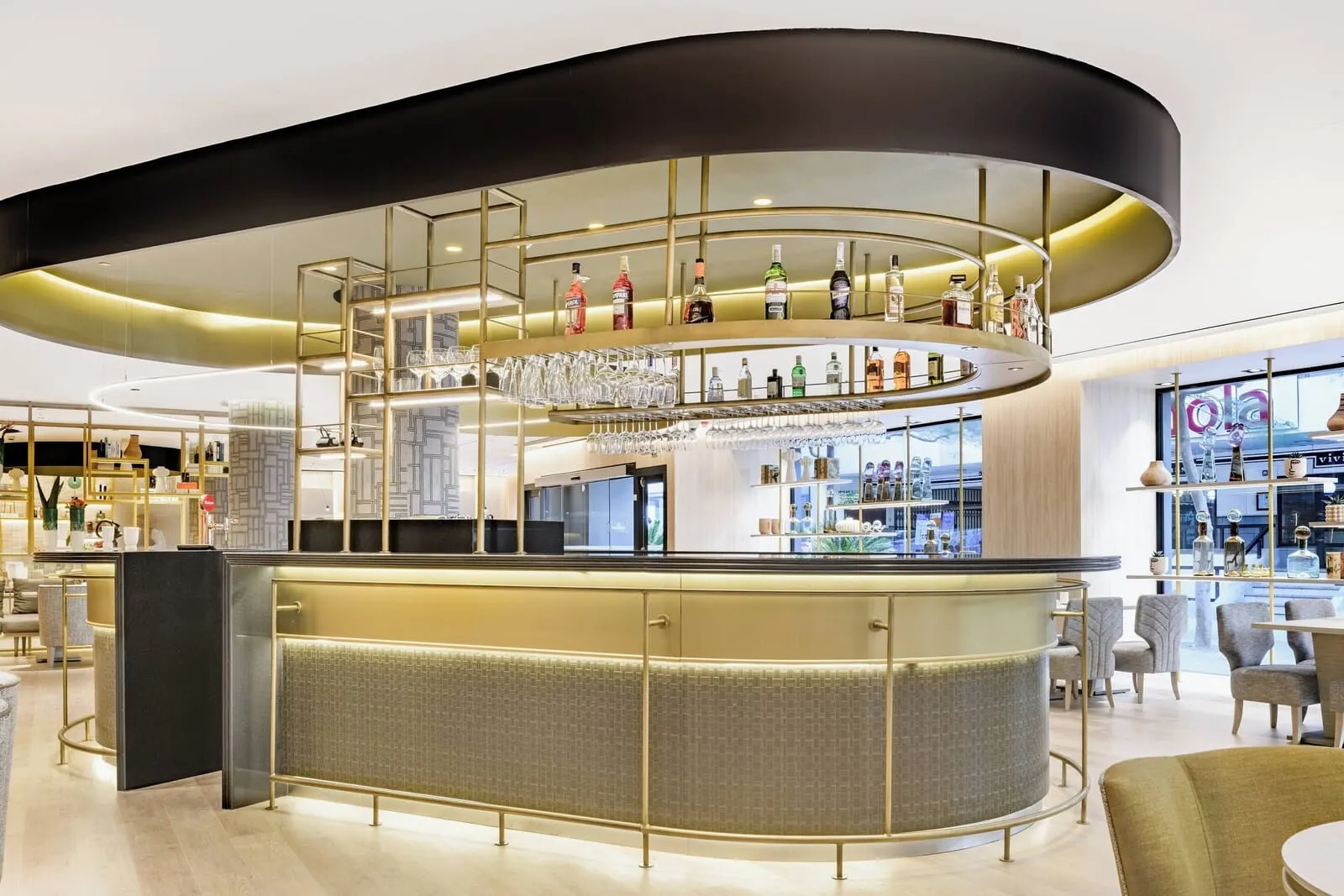 AC Hotel Tenerife: A modern bar area with a curved counter, multiple shelves of bottles