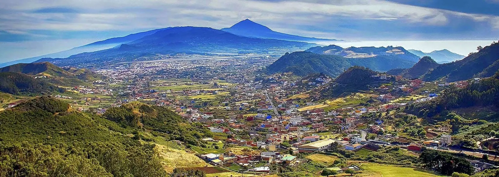 Adonis La Suite: A town nestled in a valley with a prominent mountain in the background