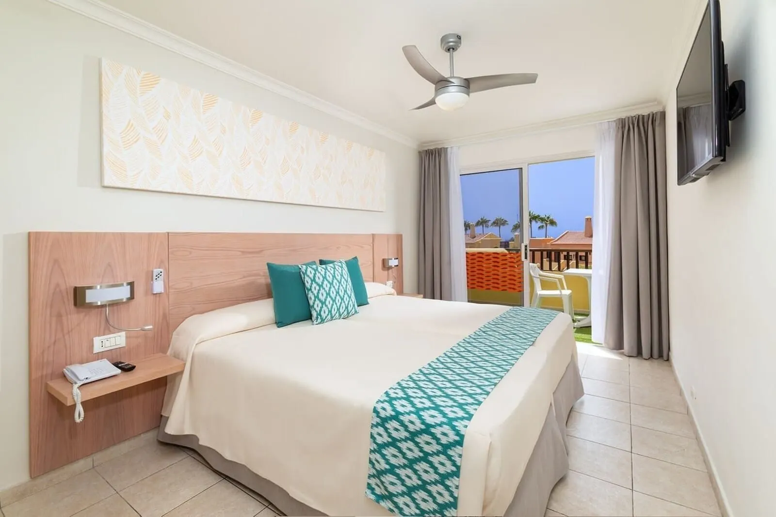 Tagoro Family & Fun Costa Adeje: A hotel room with a large bed, a ceiling fan, a TV mounted on the wall