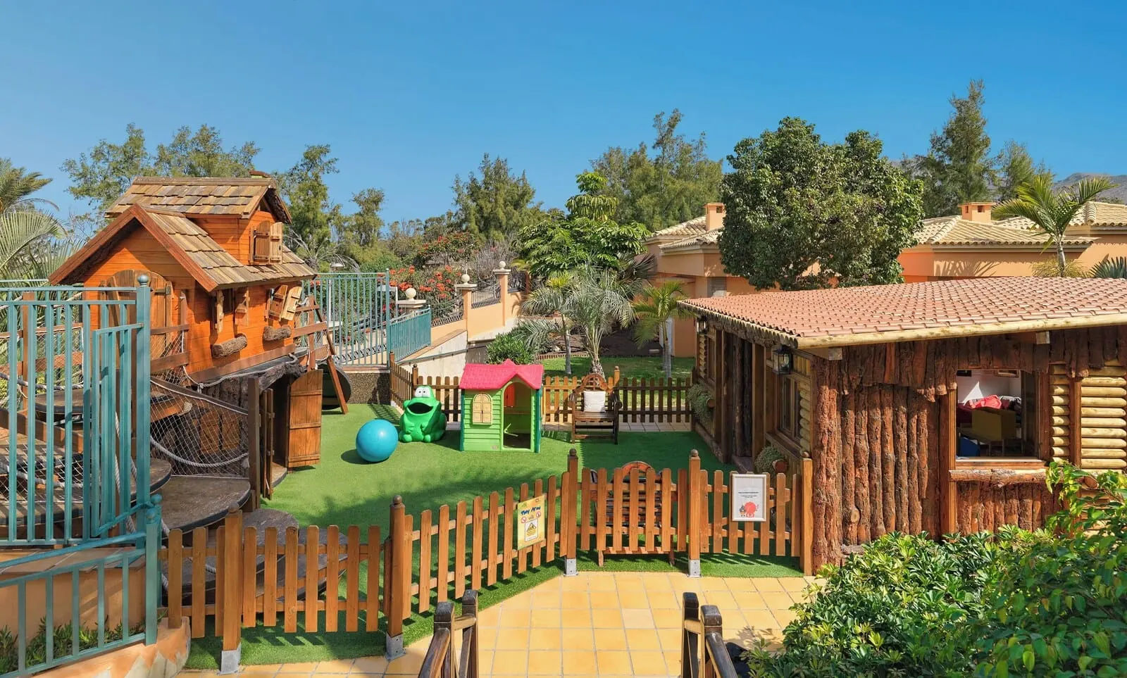 Green Garden Eco Resort & Villas: A wooden play area with a fenced entrance, a small green playhouse
