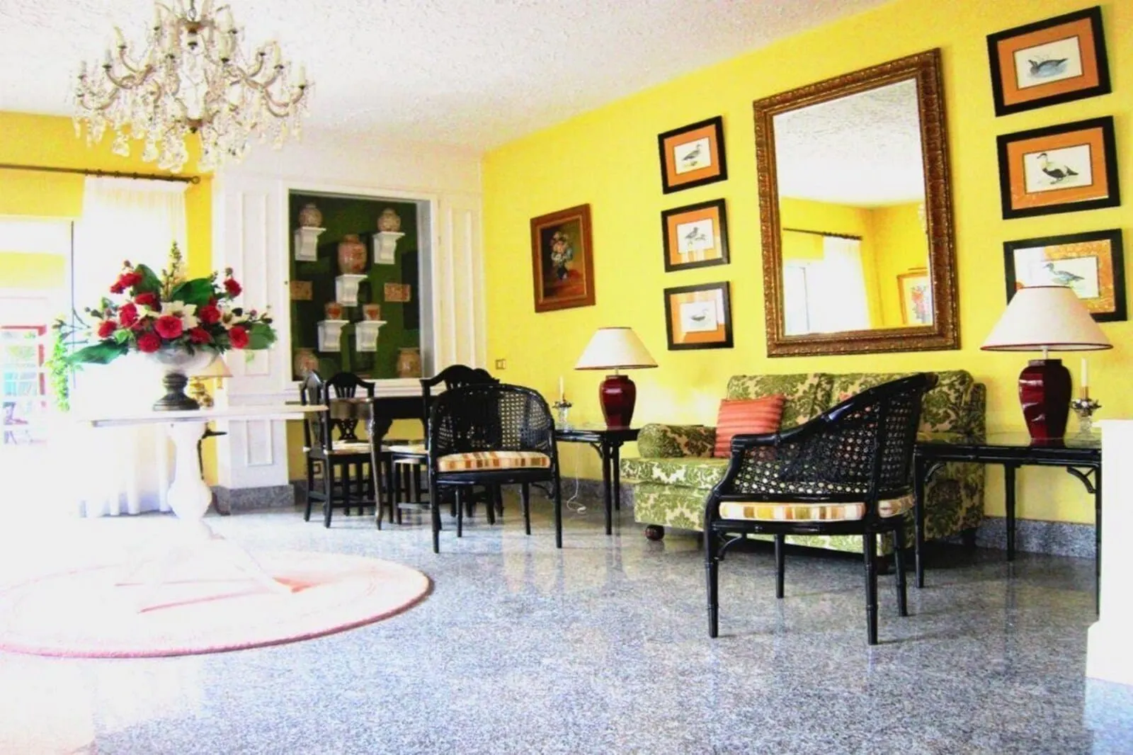 Hotel Don Cándido: A room with a yellow wall, a chandelier, framed pictures, a sofa