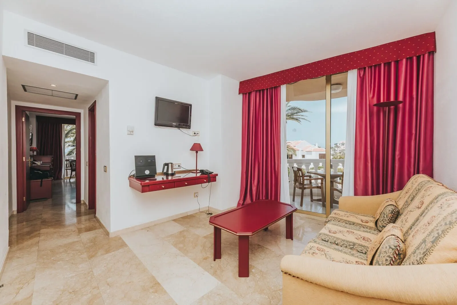 Cleopatra Palace: A hotel room with a sofa, a small table, a TV mounted on the wall