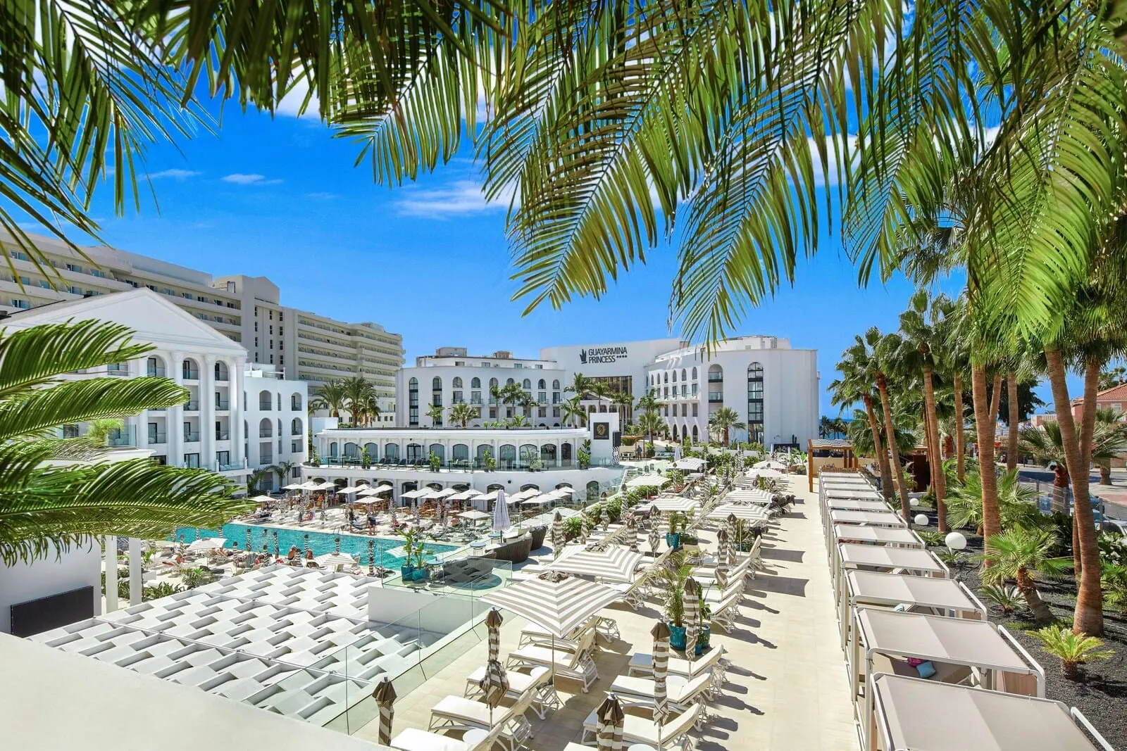 Princess Inspire Tenerife: A resort with a pool area, sun loungers, and palm trees