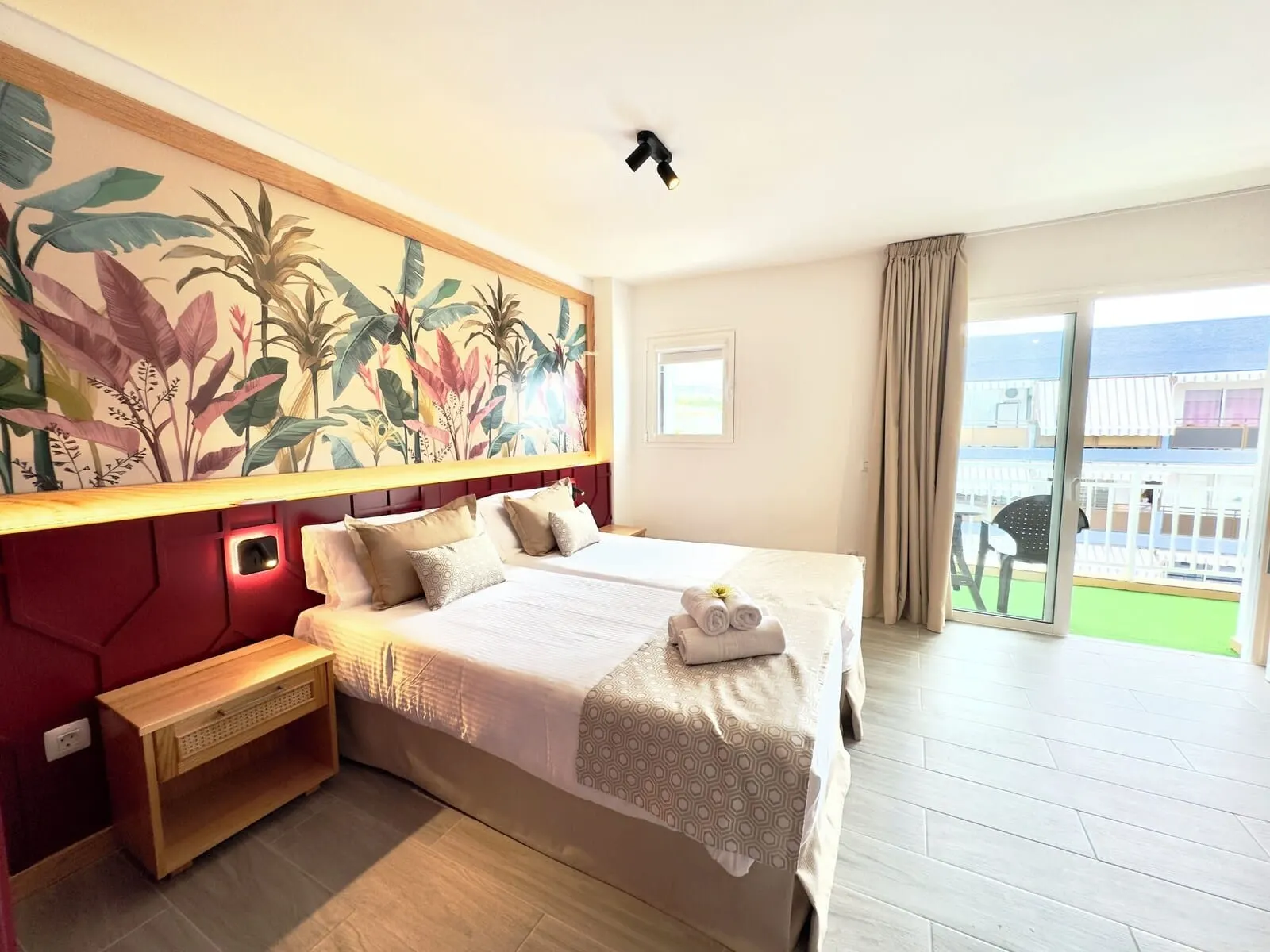 Skyview Hotel by LIVVO: A hotel room with a large bed, a wooden nightstand, a wall-mounted light