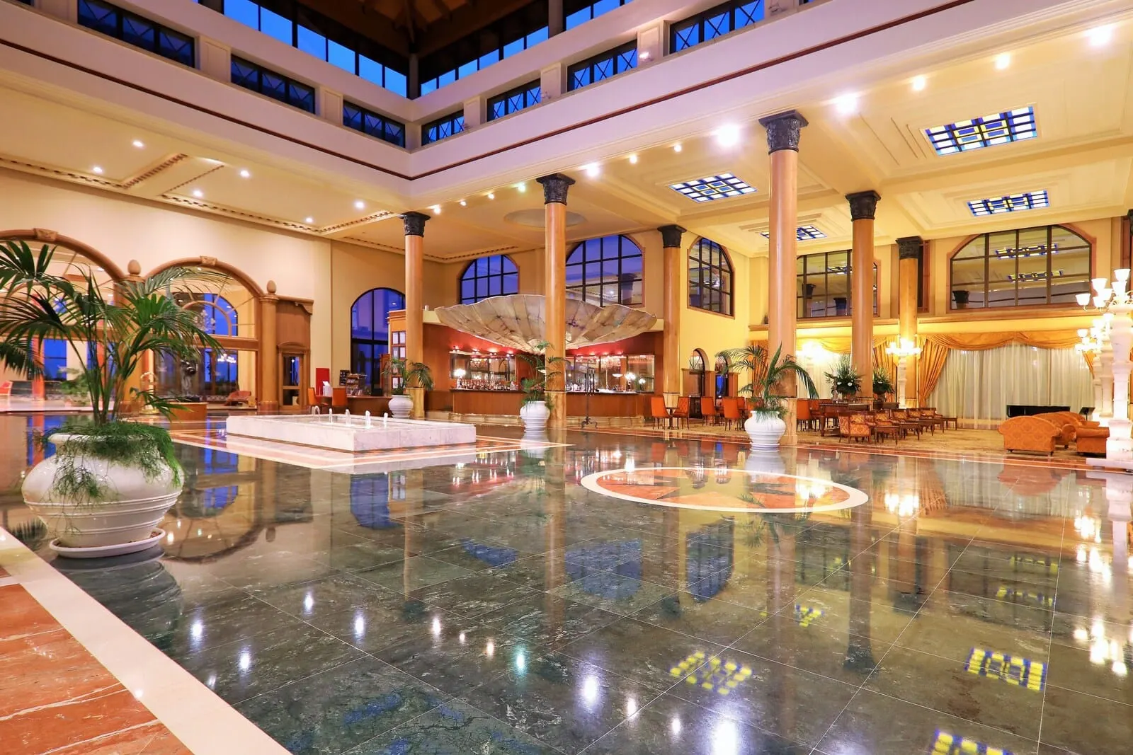 JOIA Salomé by Iberostar: A spacious lobby with a polished marble floor, large columns, and a bar area