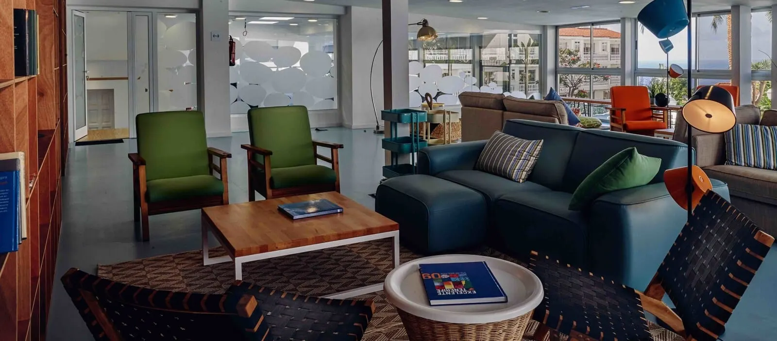 Route Active Hotel: A modern living room with a blue sofa, green armchairs, and a wooden coffee table