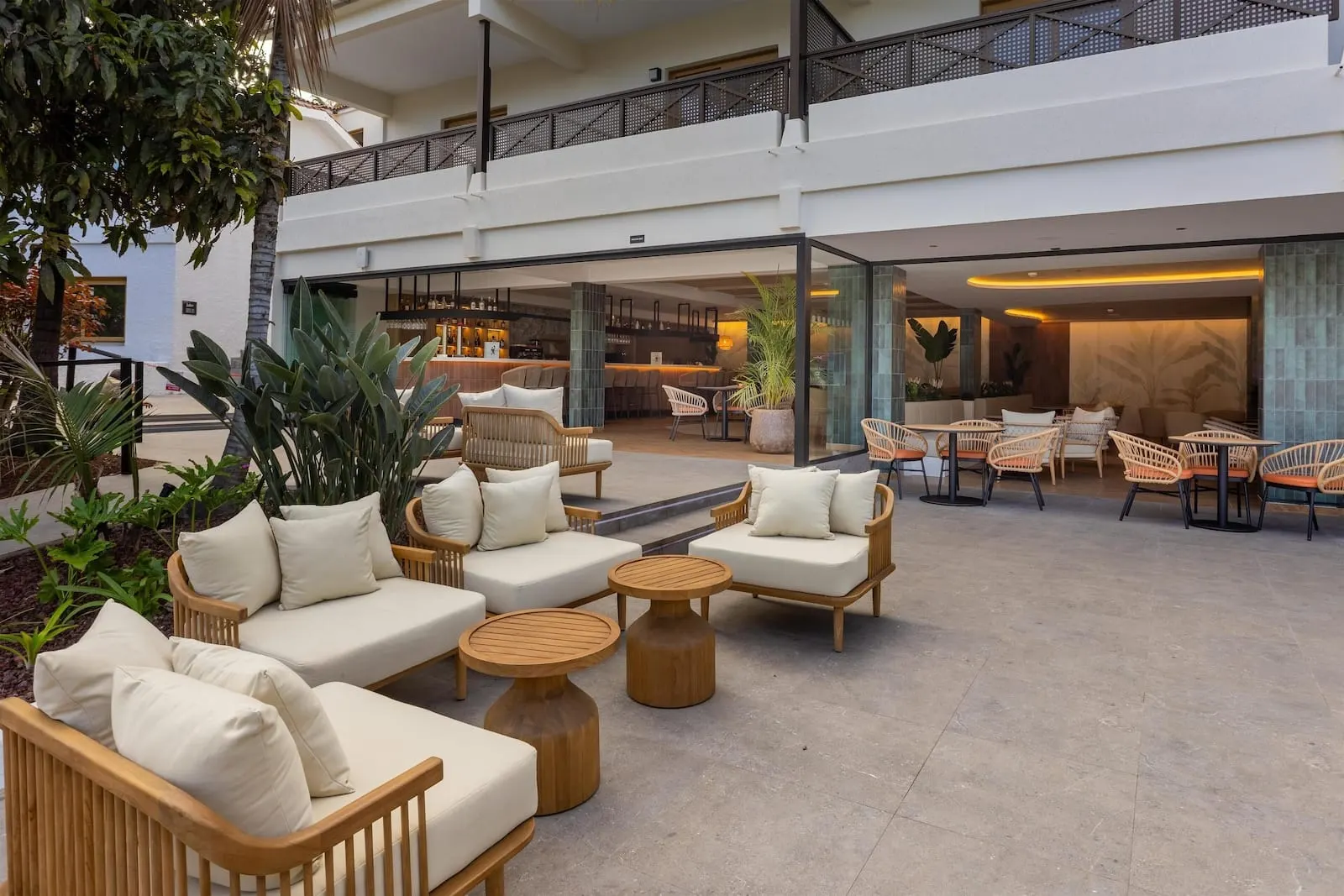 Radisson Resort & Residences Tenerife: A spacious outdoor seating area with wicker furniture and a bar in the background