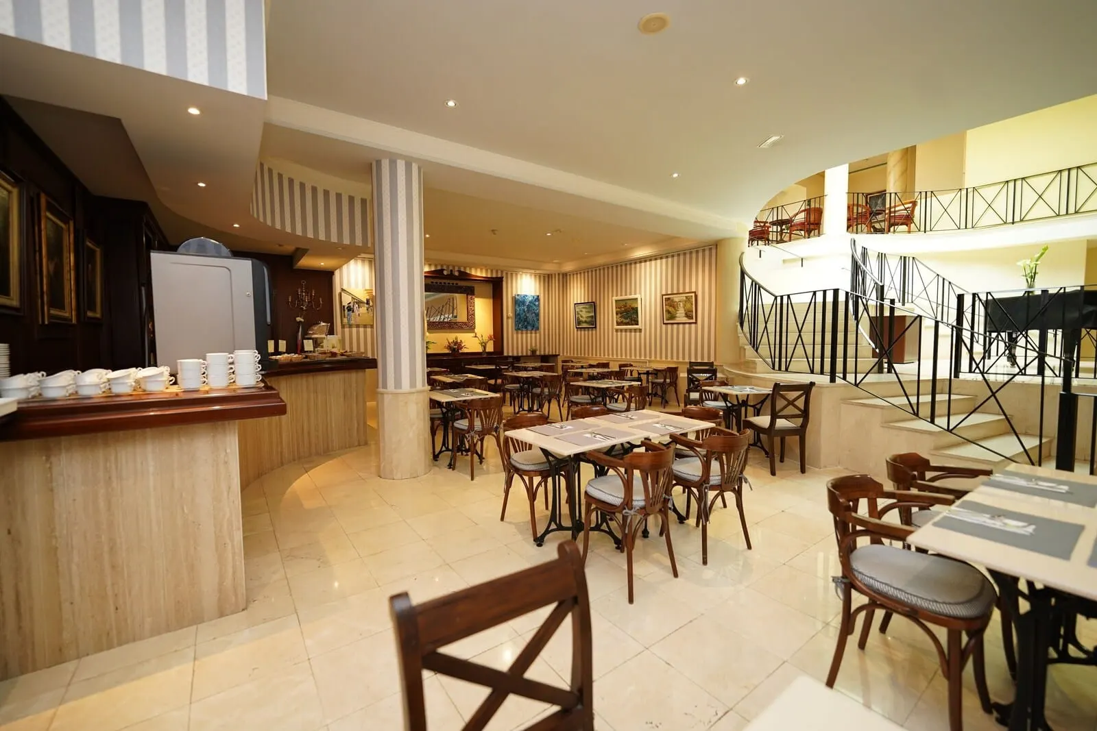 RF Apartamentos Bambi: A spacious hotel dining area with multiple tables and chairs, a central column