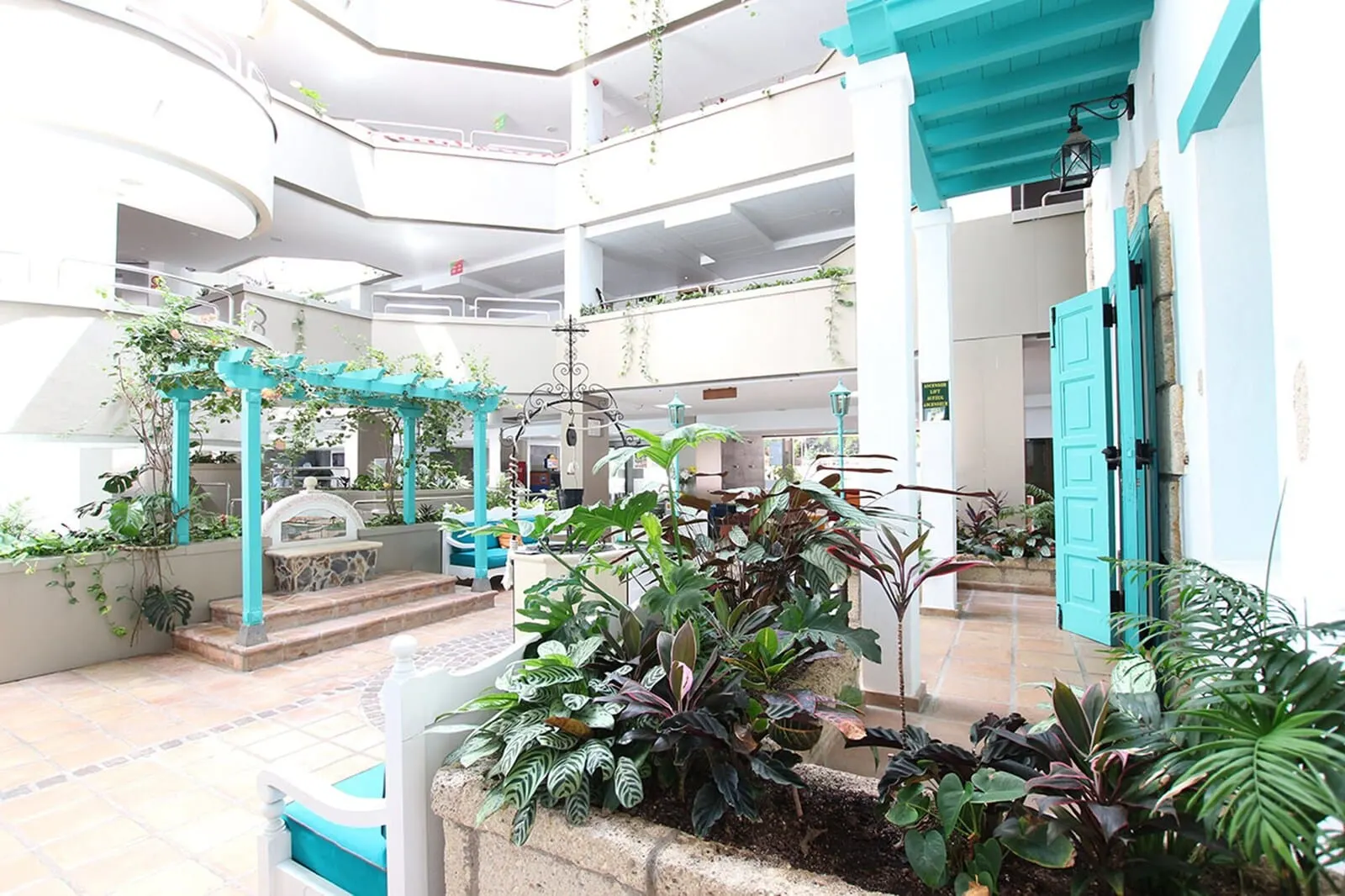 Paradise Park Fun Lifestyle Hotel: A multi-level atrium with a central garden area, multiple seating arrangements
