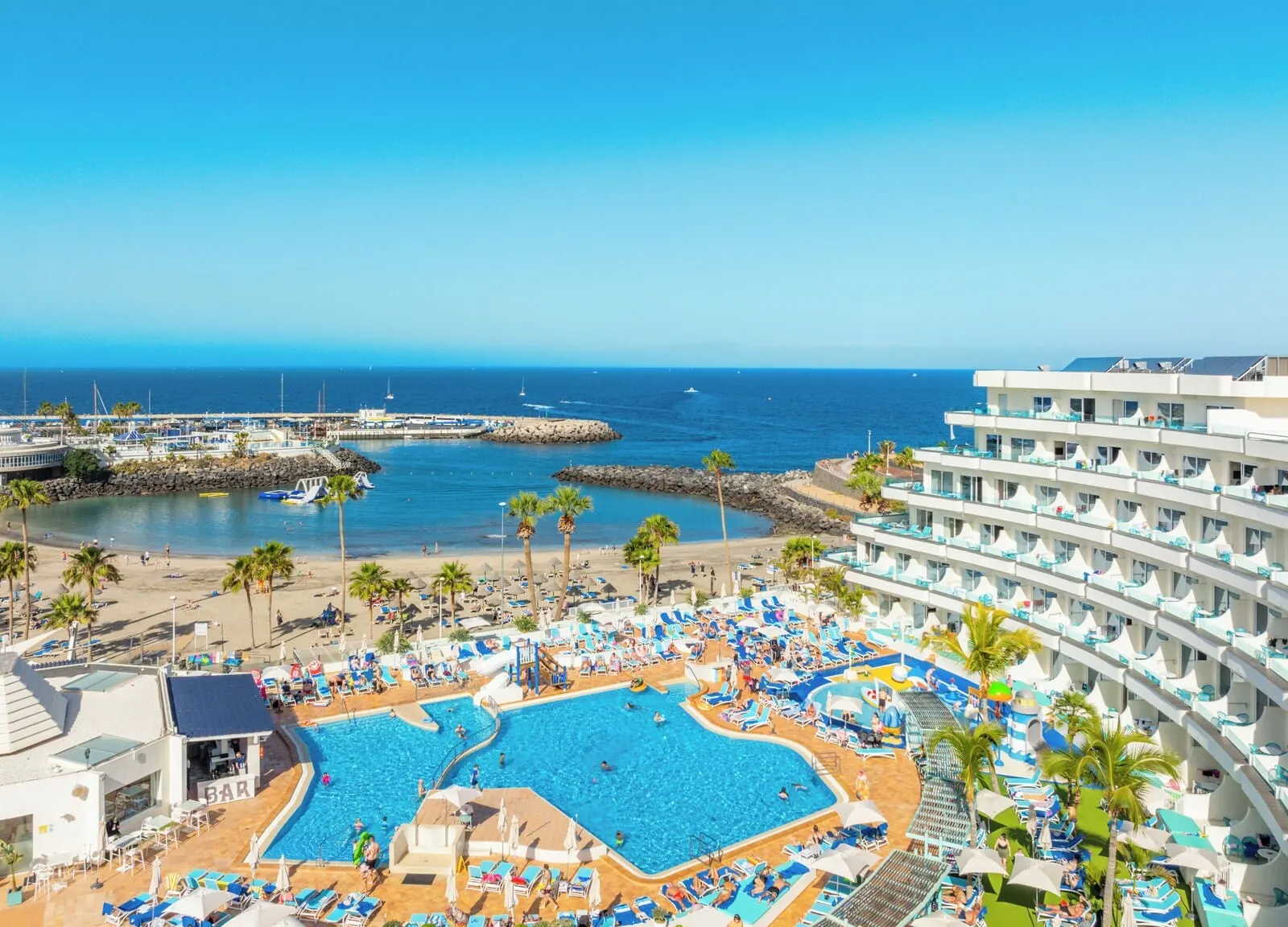 HOVIMA La Pinta Beachfront Family Hotel: A resort with a large pool area, multiple levels of balconies, and a view of the sea