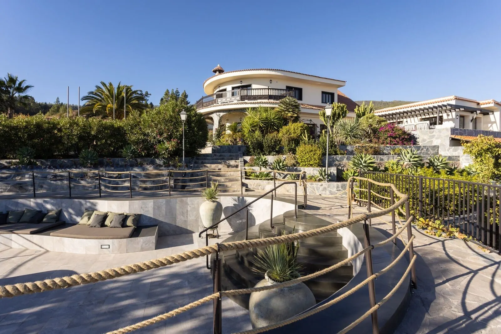 Hotel Alta Montaña: A modern building with a curved balcony, a pool area with a seating area