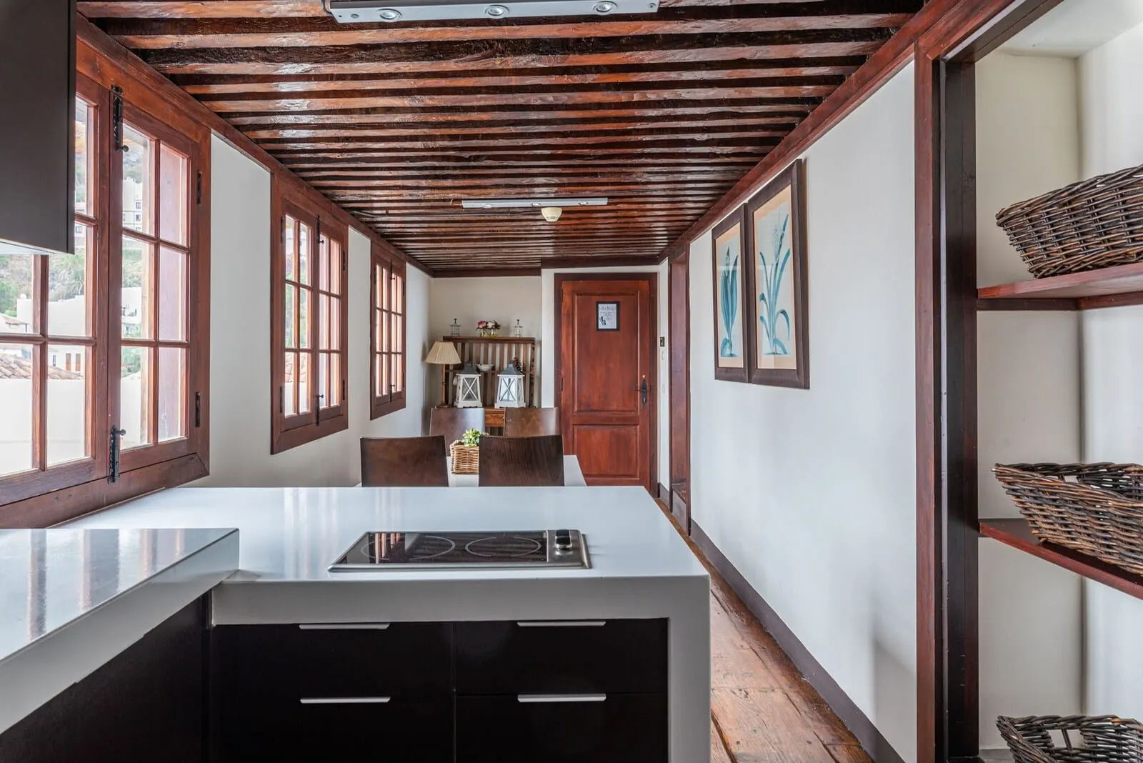 Isla Baja Suites: A kitchen with a central island, wooden beams on the ceiling, large windows