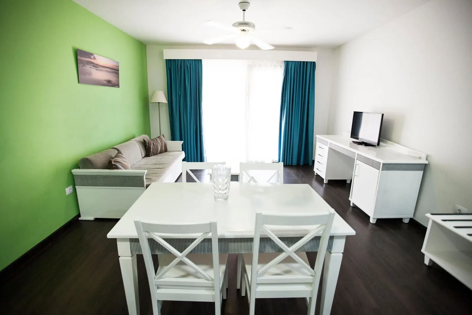 Coral Los Alisios: A modern living room with a dining table, white furniture, a TV