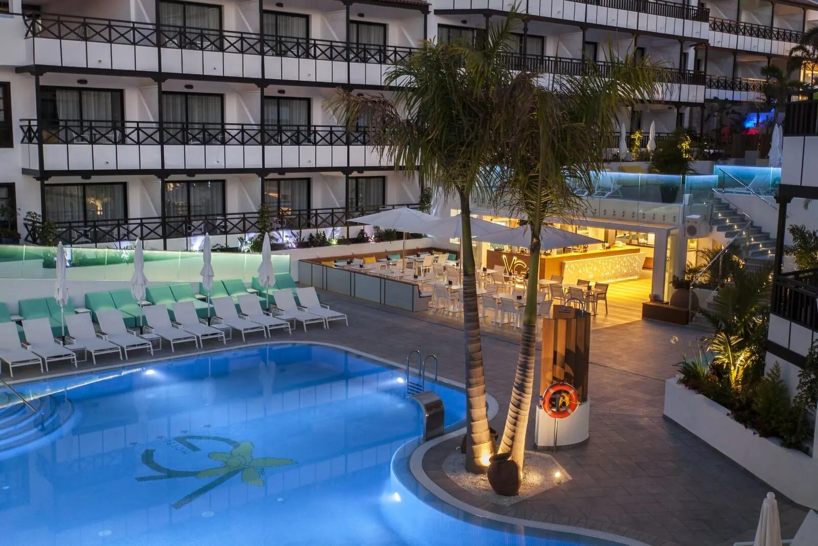 Vanilla Garden Boutique Hotel: A hotel pool area with a large pool, lounge chairs, and a bar area