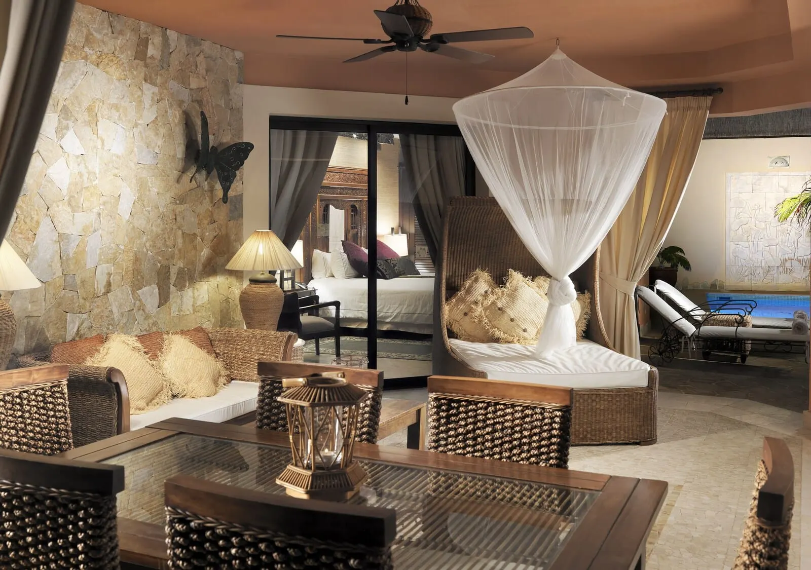 Royal Garden Villas & Spa: A spacious living area with a large bed, wicker furniture, a glass coffee table