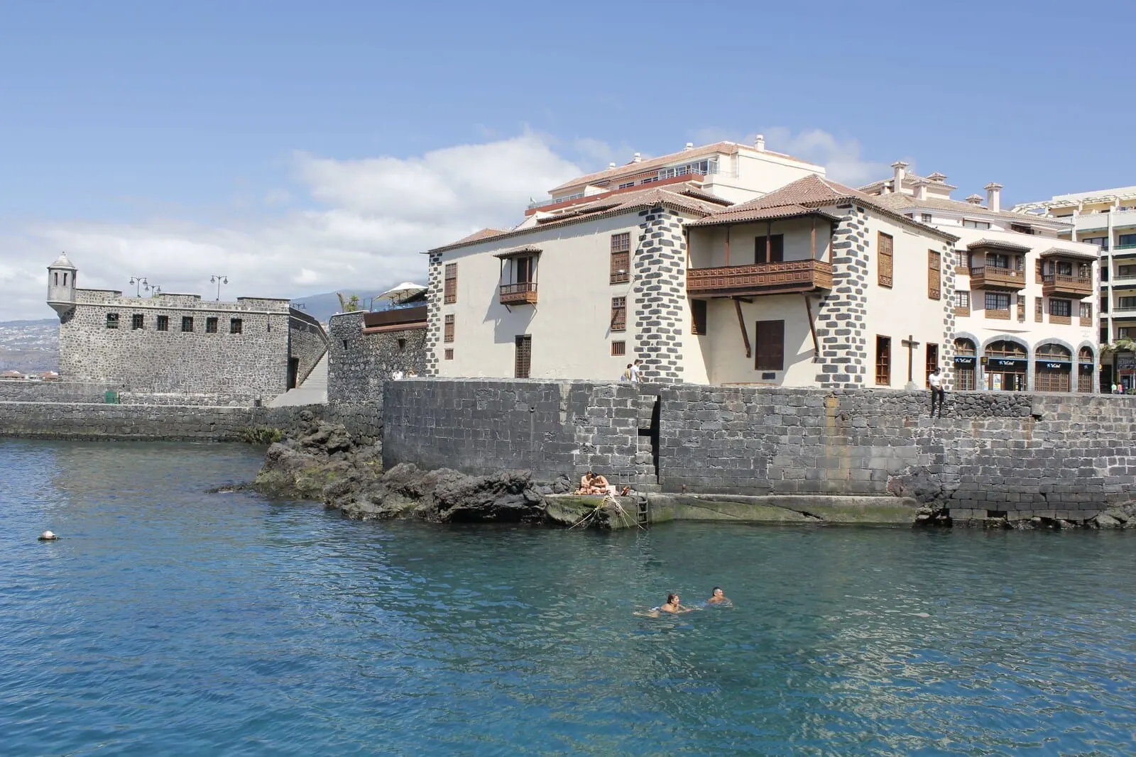 4Dreams Hotel: A coastal building with stone walls and a balcony overlooking the water