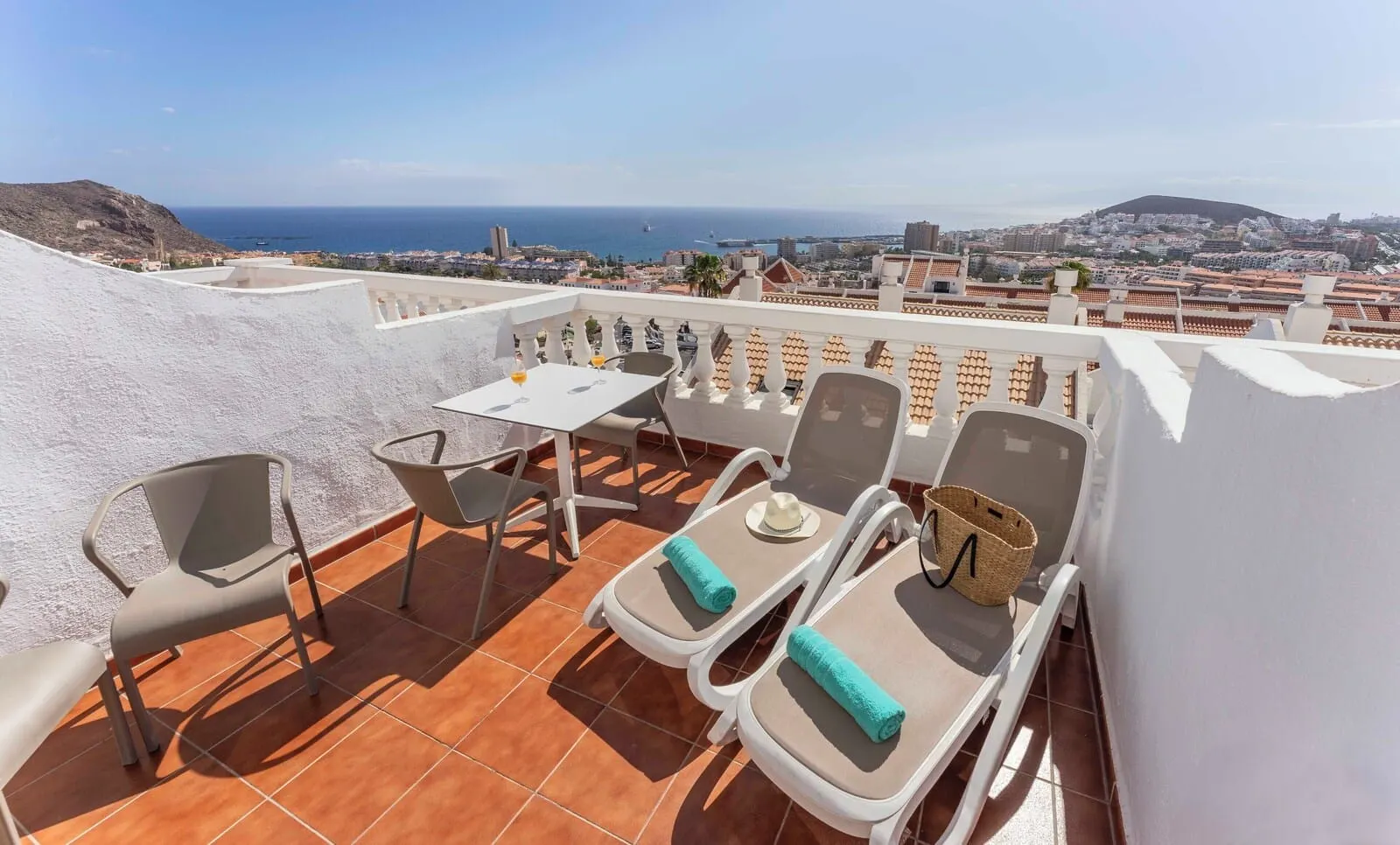 Ona Hollywood Mirage: A terrace with a table and chairs, overlooking a coastal cityscape