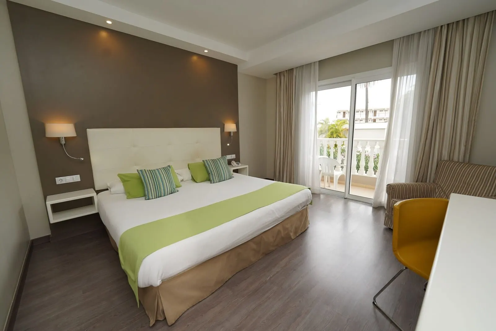 Hotel RF San Borondón: A hotel room with a large bed, a desk, a chair, and a balcony with curtains