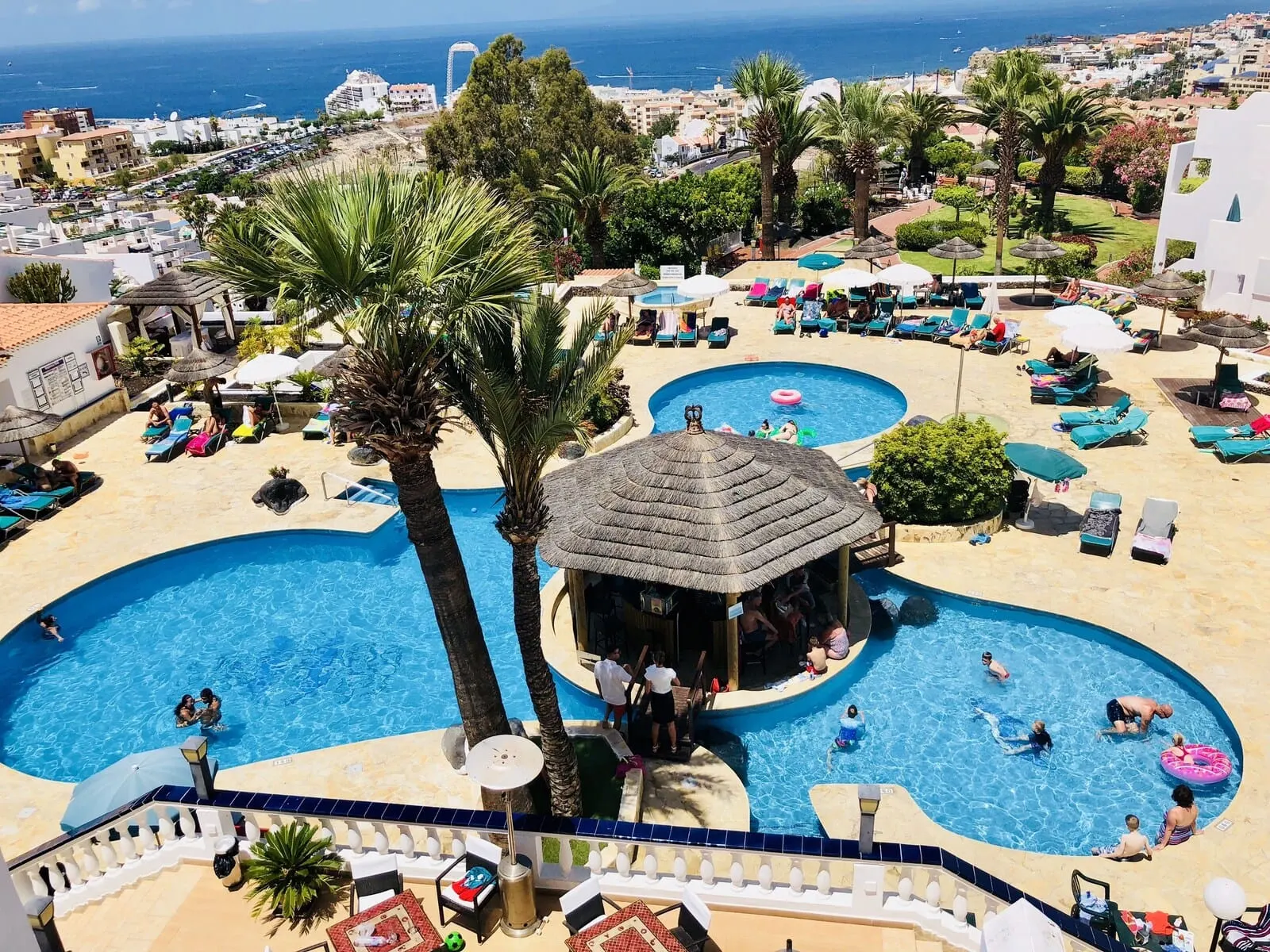 Regency Torviscas Apartments & Suites: A resort pool area with multiple pools, lounge chairs, and palm trees